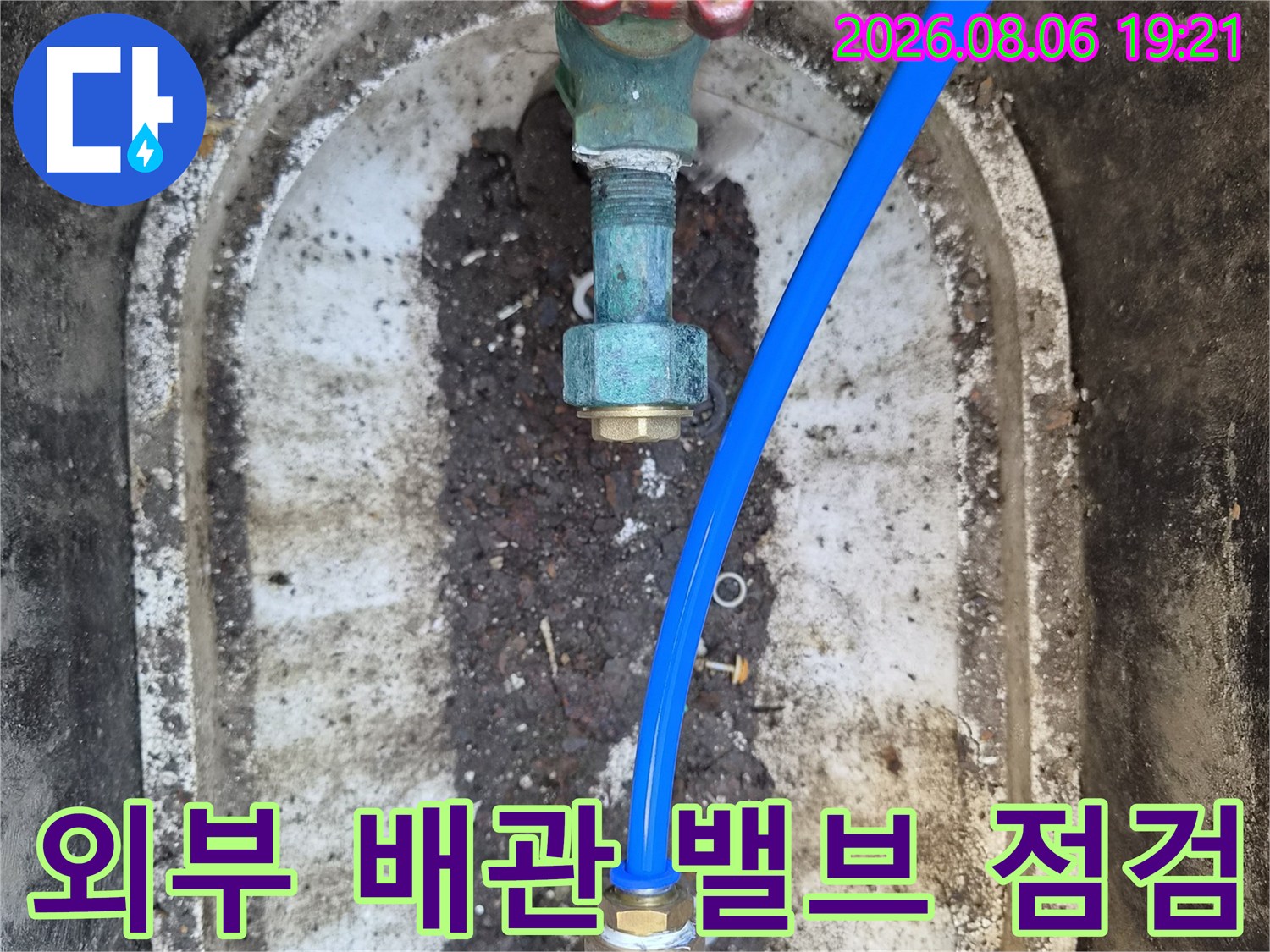 외부 매립 배관함 내부의 파란색 관과 밸브 연결 부위 점검 모습
