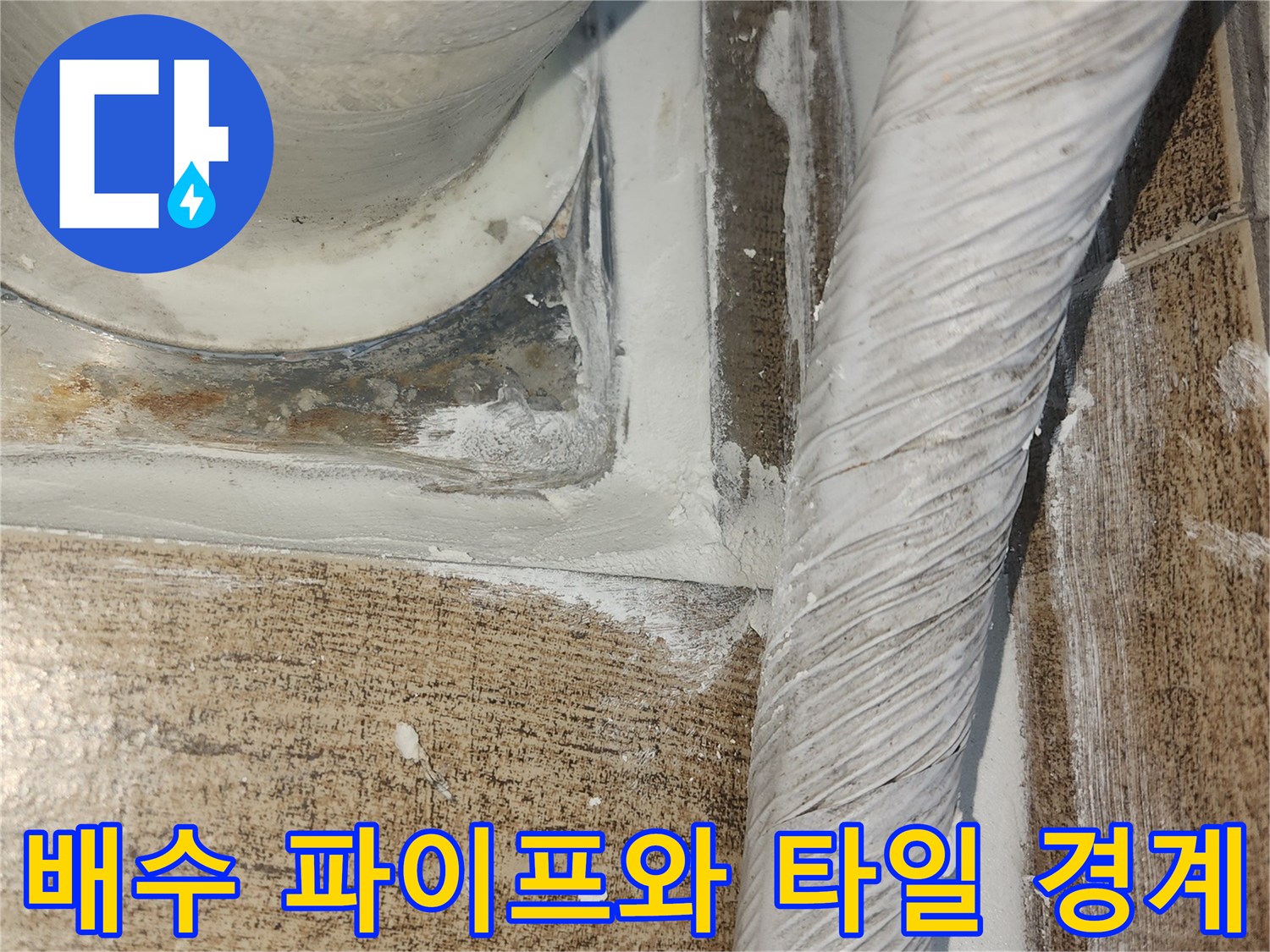 하얀 배관과 갈색 타일 사이의 벌어진 틈새 촬영