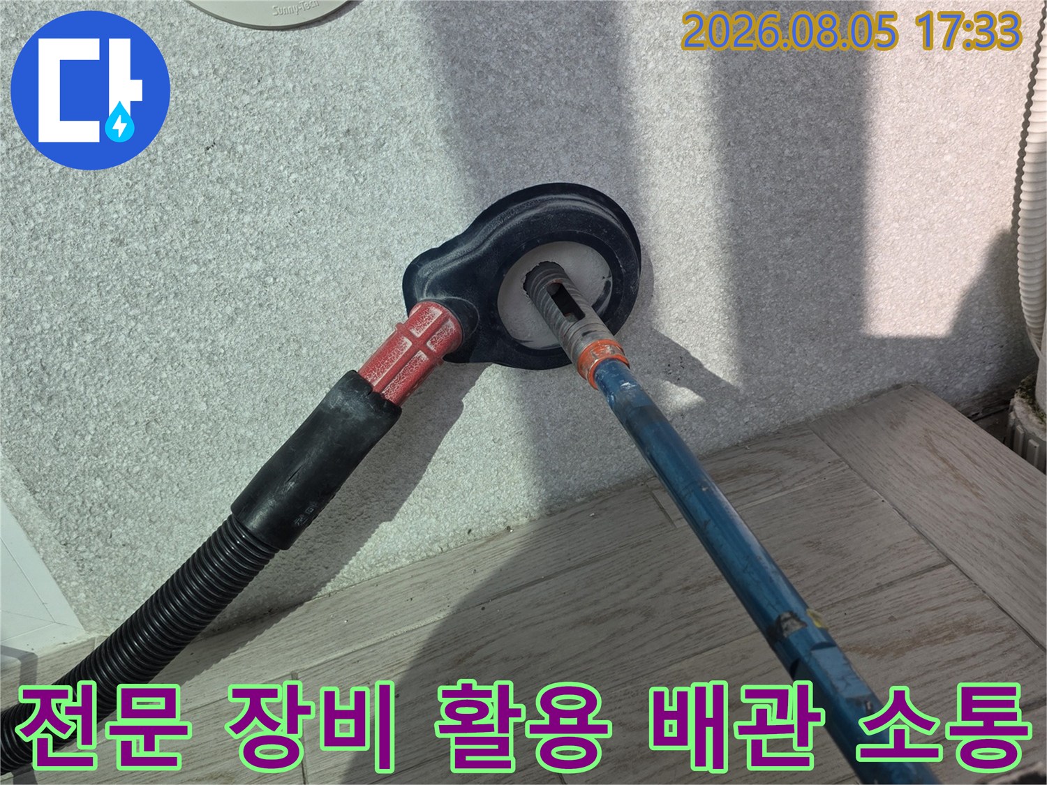 세탁실 하수구 내부에 쌓인 찌꺼기를 제거하기 위한 전문 장비 가동 모습