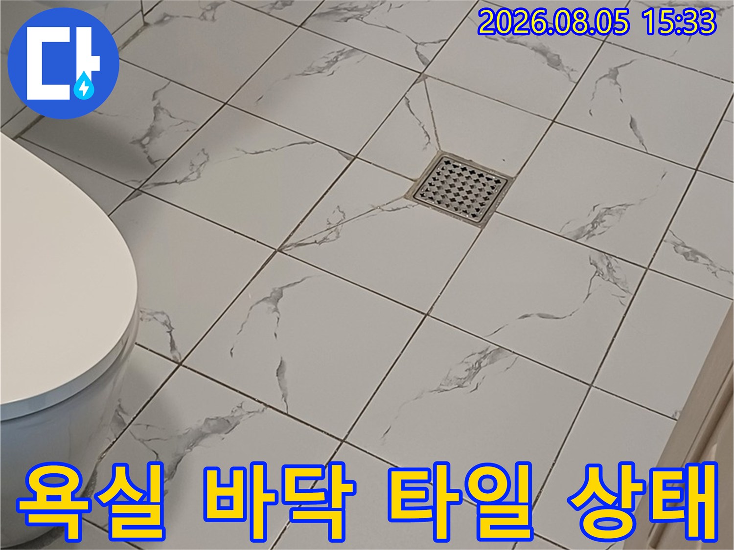 하얀색 욕실 타일과 배수구 주변의 모습 - 누수 점검 현장