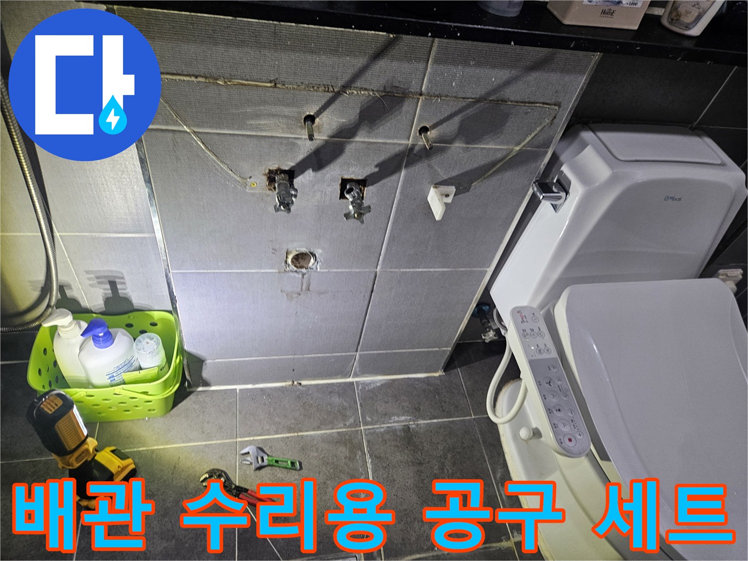 작업을 위해 바닥에 배치된 스패너와 전동 드릴 및 세정제
