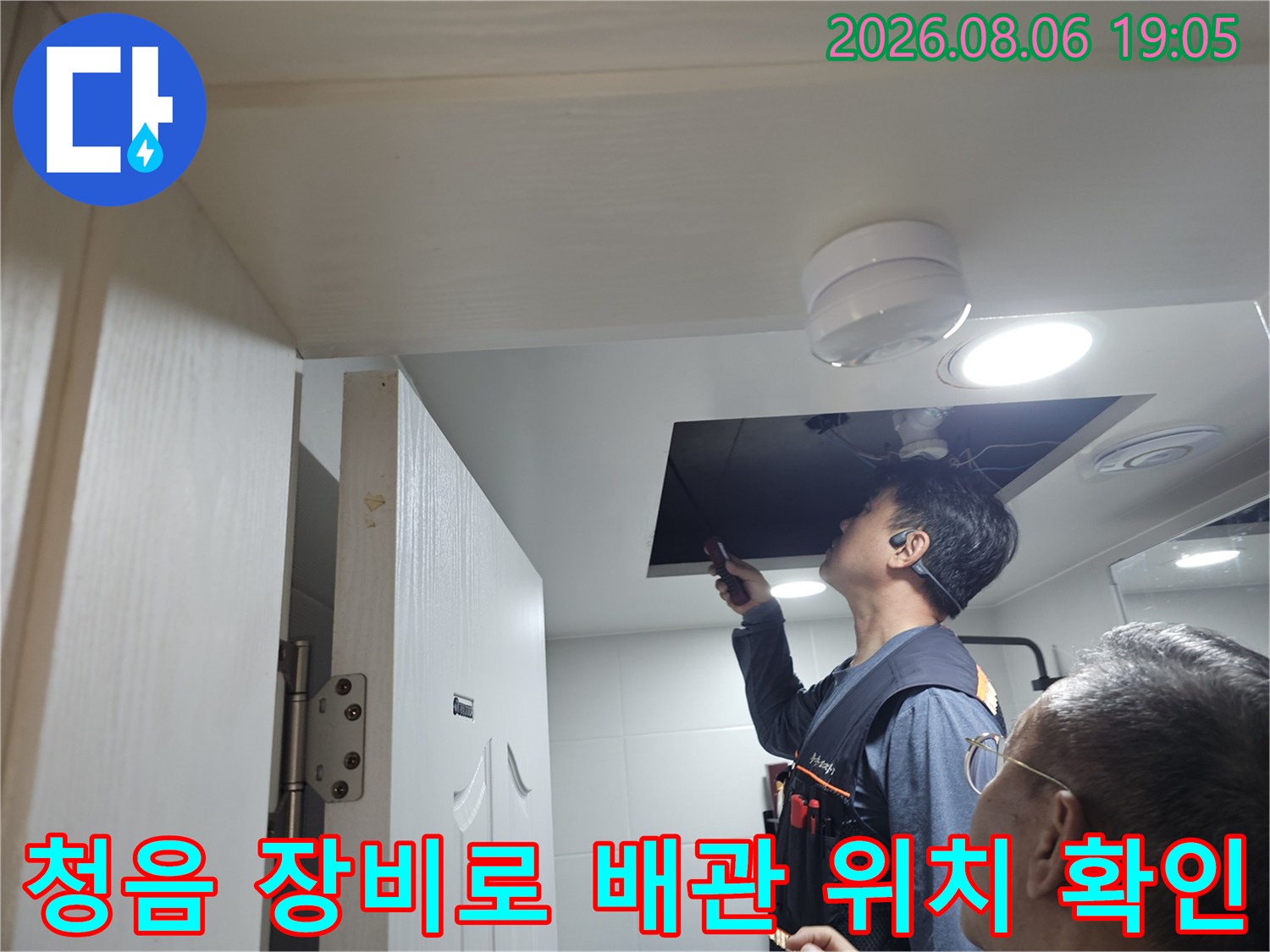 천장 내부의 누수 지점을 찾기 위해 청음식 탐지기로 배관 상태를 정밀 점검하는 모습