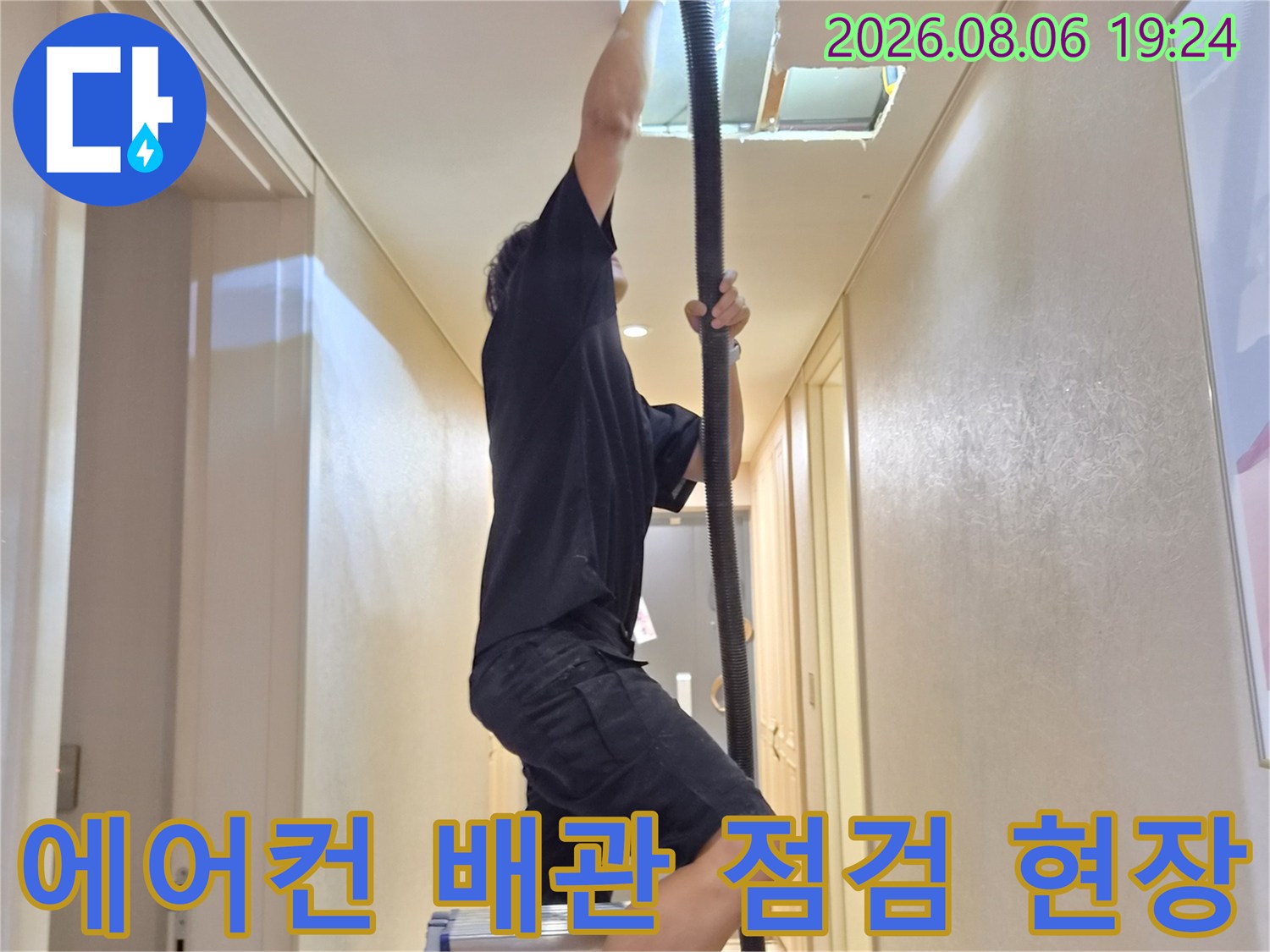 천장 내부의 에어컨 배수 배관을 확인 중인 작업자 모습