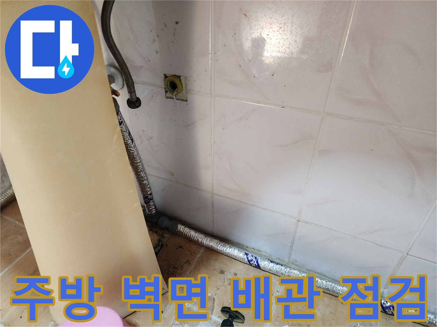 싱크대 밑쪽-은박 보온재로 감싸진 수도 배관의 모습