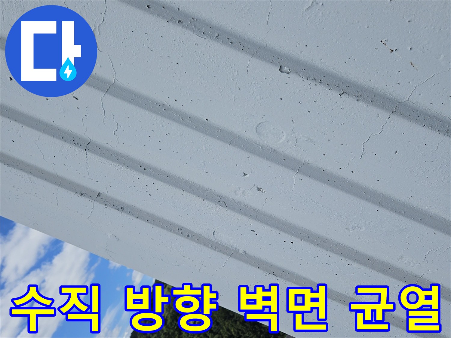 아파트 외벽의 수직 패턴과 그 사이에 발생한 미세한 크랙을 나타내는 사진입니다.