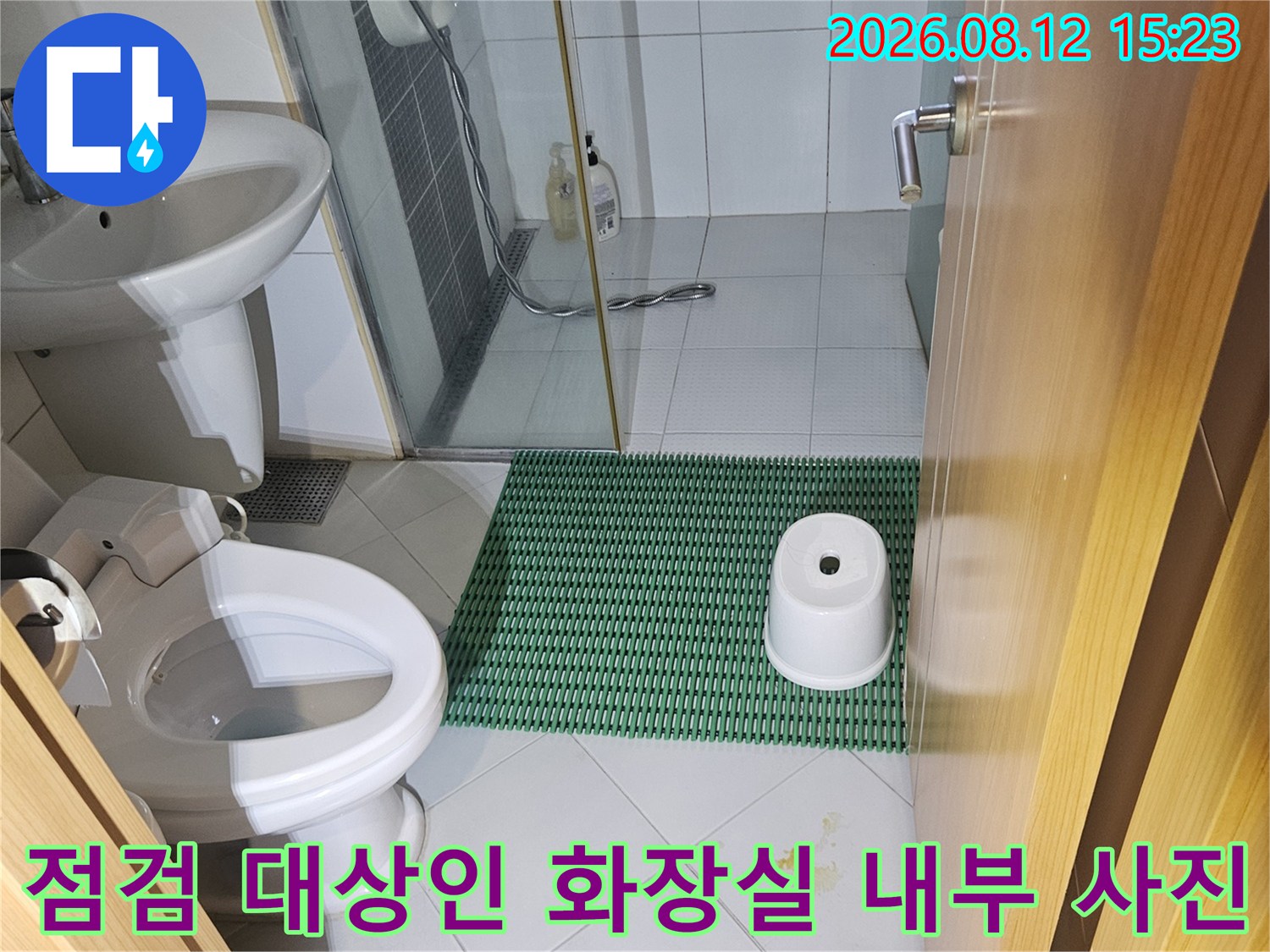 하얀색 타일로 마감된 욕실-변기와 욕조 그리고 유리 파티션이 보이는 모습