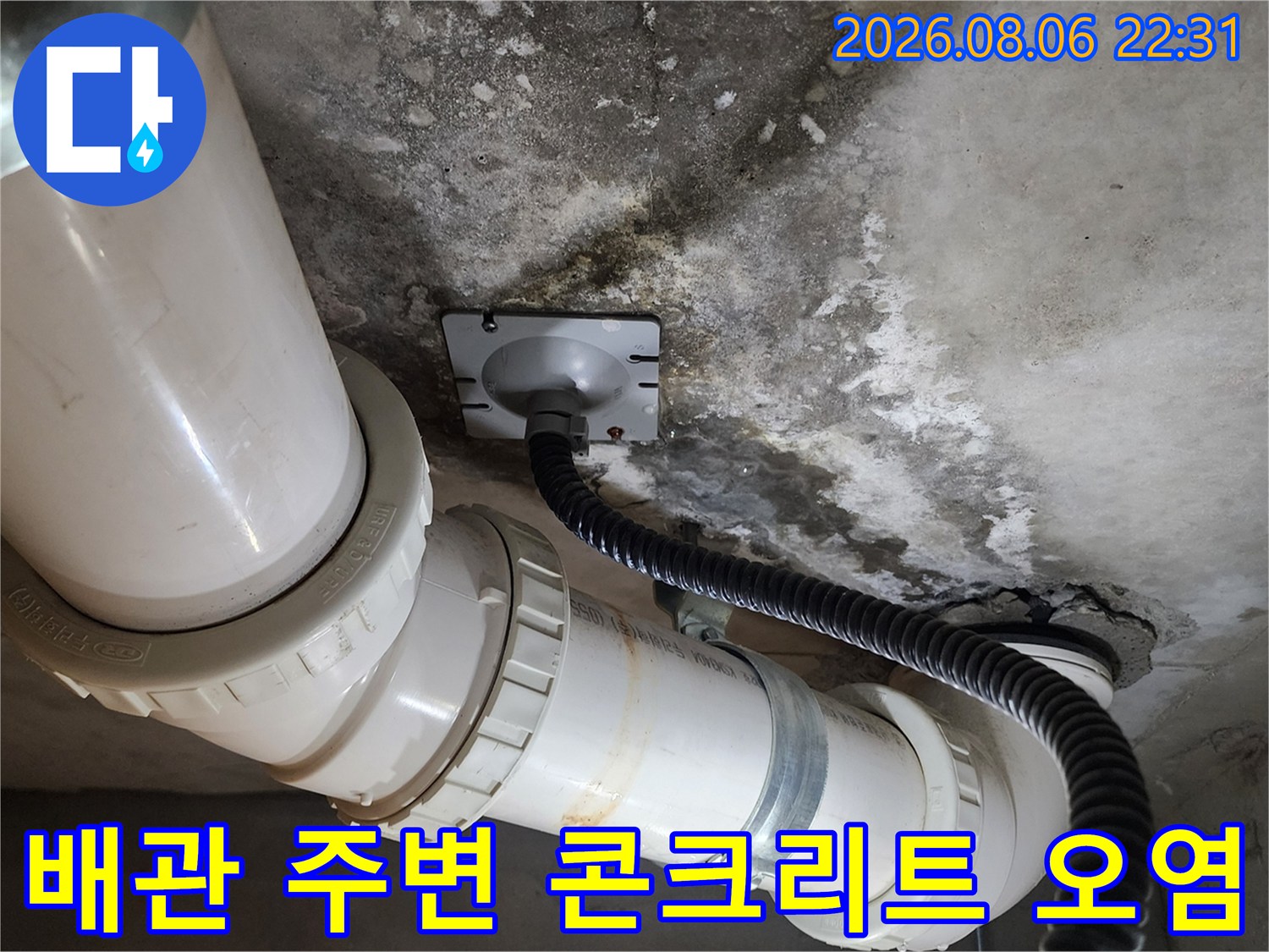 배관 주변의 젖은 콘크리트와 배관 연결부를 근접 촬영한 모습입니다.