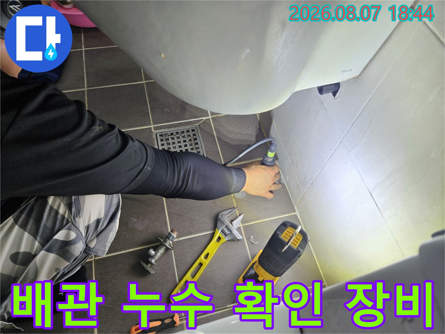 드릴과 몽키스패너를 사용하여 배관 상태를 점검하는 엔지니어의 모습