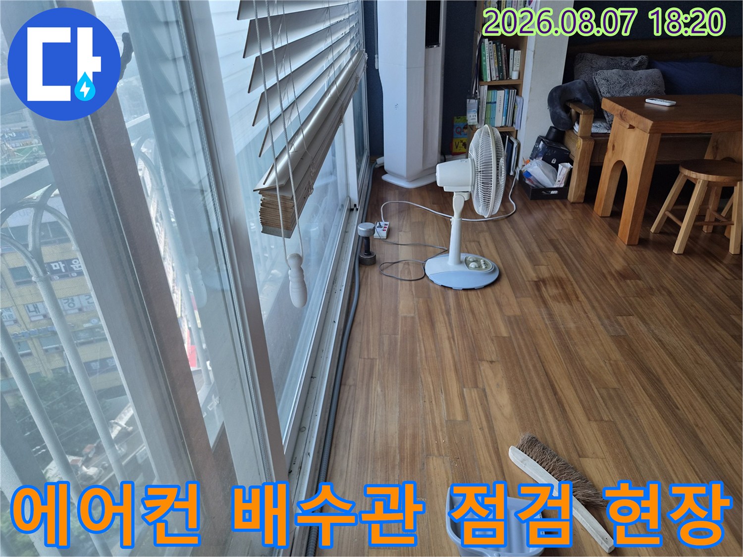 의왕 오전동 아파트 거실 창가 쪽 에어컨 배수관 누수 확인을 위해 선풍기를 틀어 건조 중인 모습