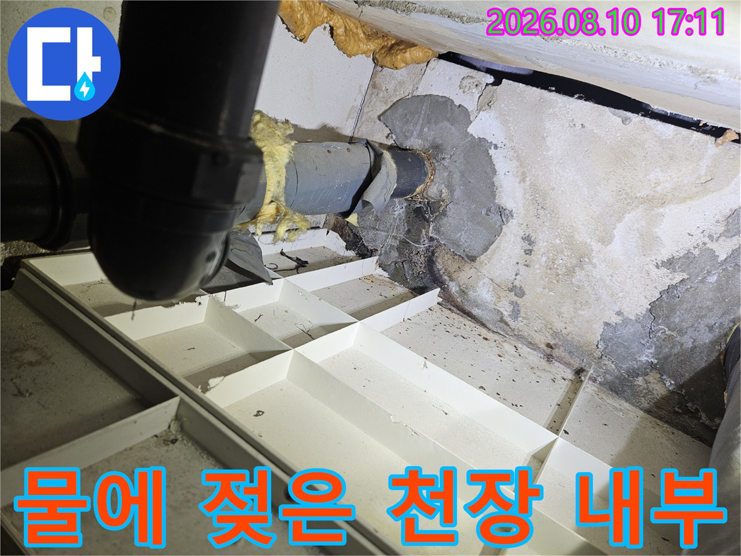 습기로 얼룩진 천장 벽면과 노출된 배관의 모습입니다.