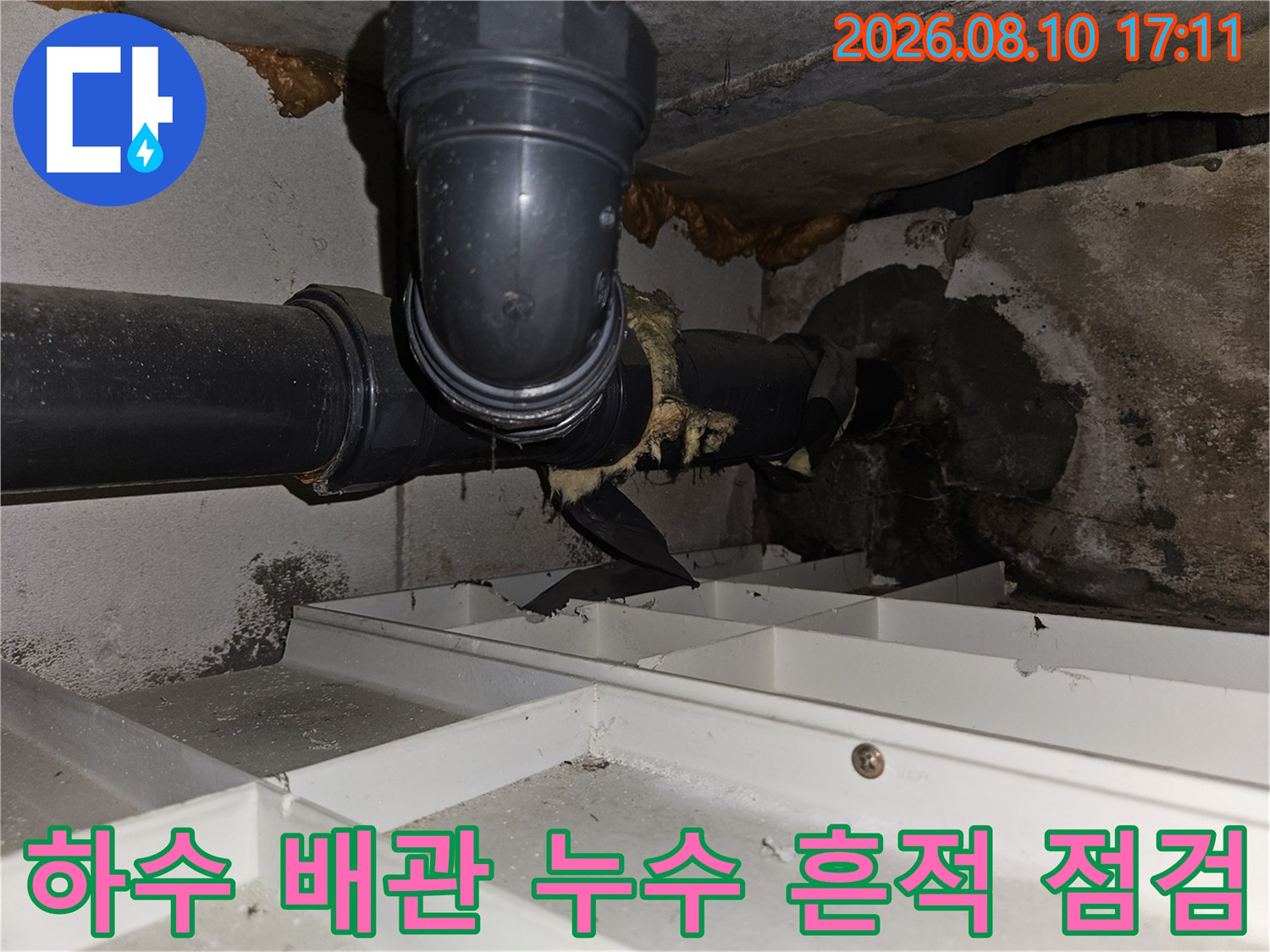 천장 내부 하수 배관의 물자국과 습기 상태를 보여줍니다.