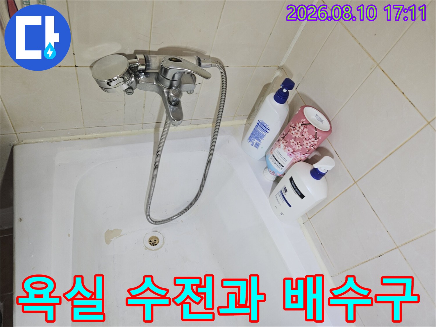 화장실 욕조 내부의 수전 부위와 하단 배수구 상태를 보여줍니다.