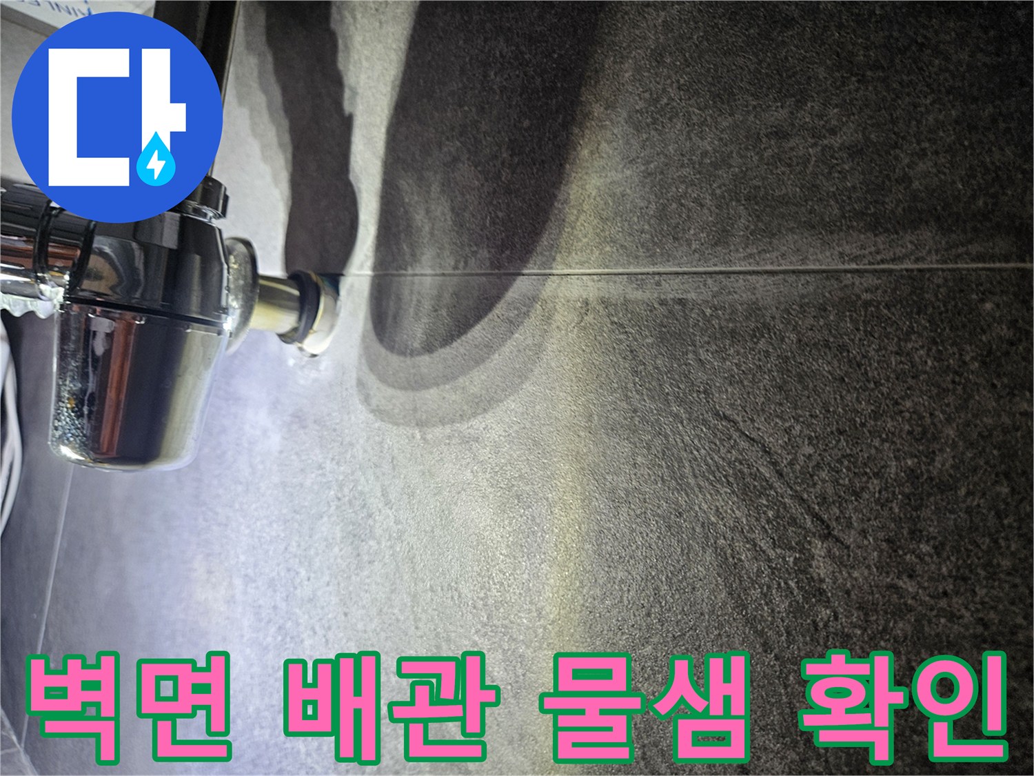 어두운 회색 타일과 크롬 배관의 연결 부위 상세 사진
