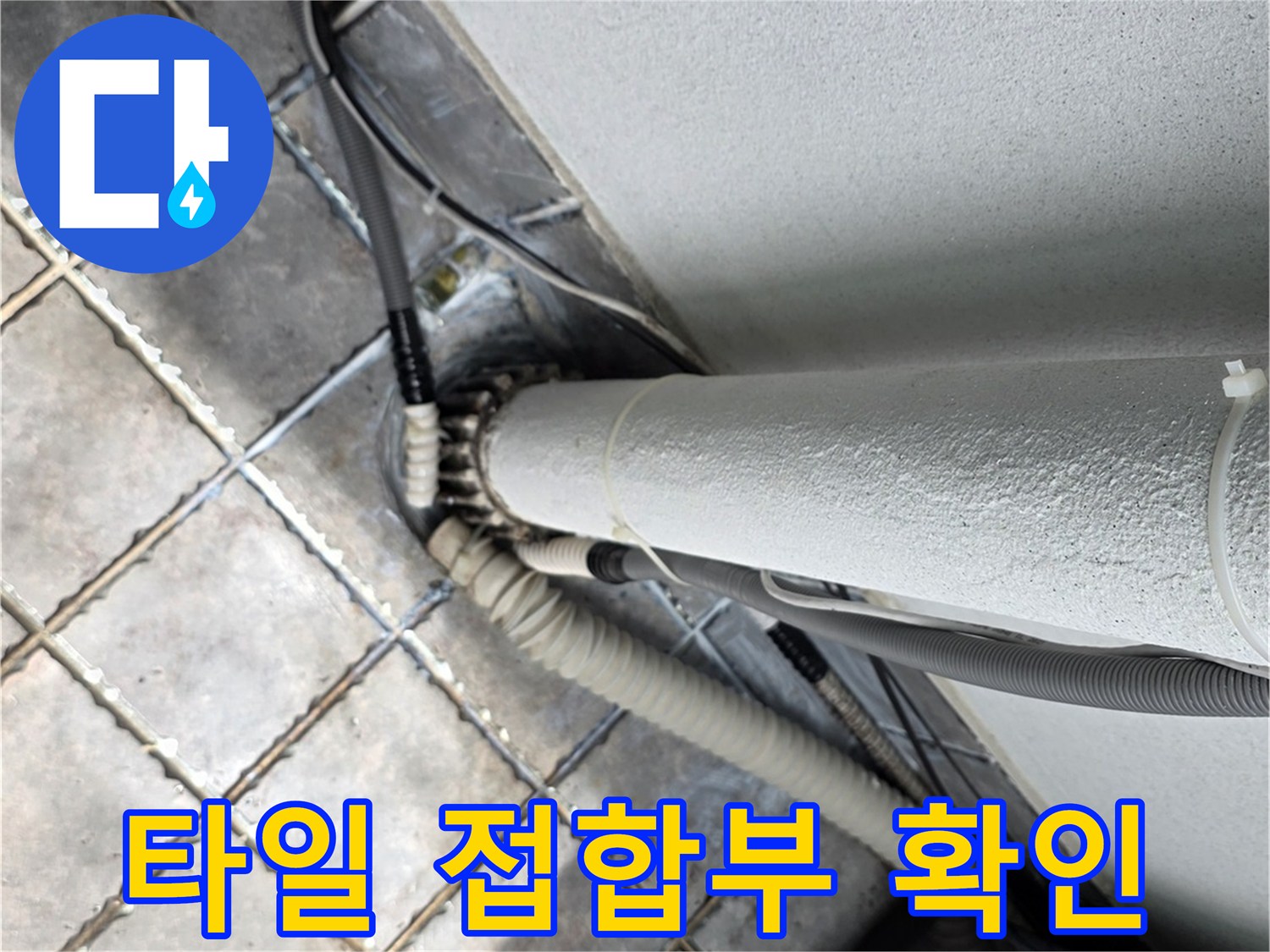 배관 주변 타일 사이의 틈새와 노후된 연결 부위 상태를 보여주는 사진입니다.