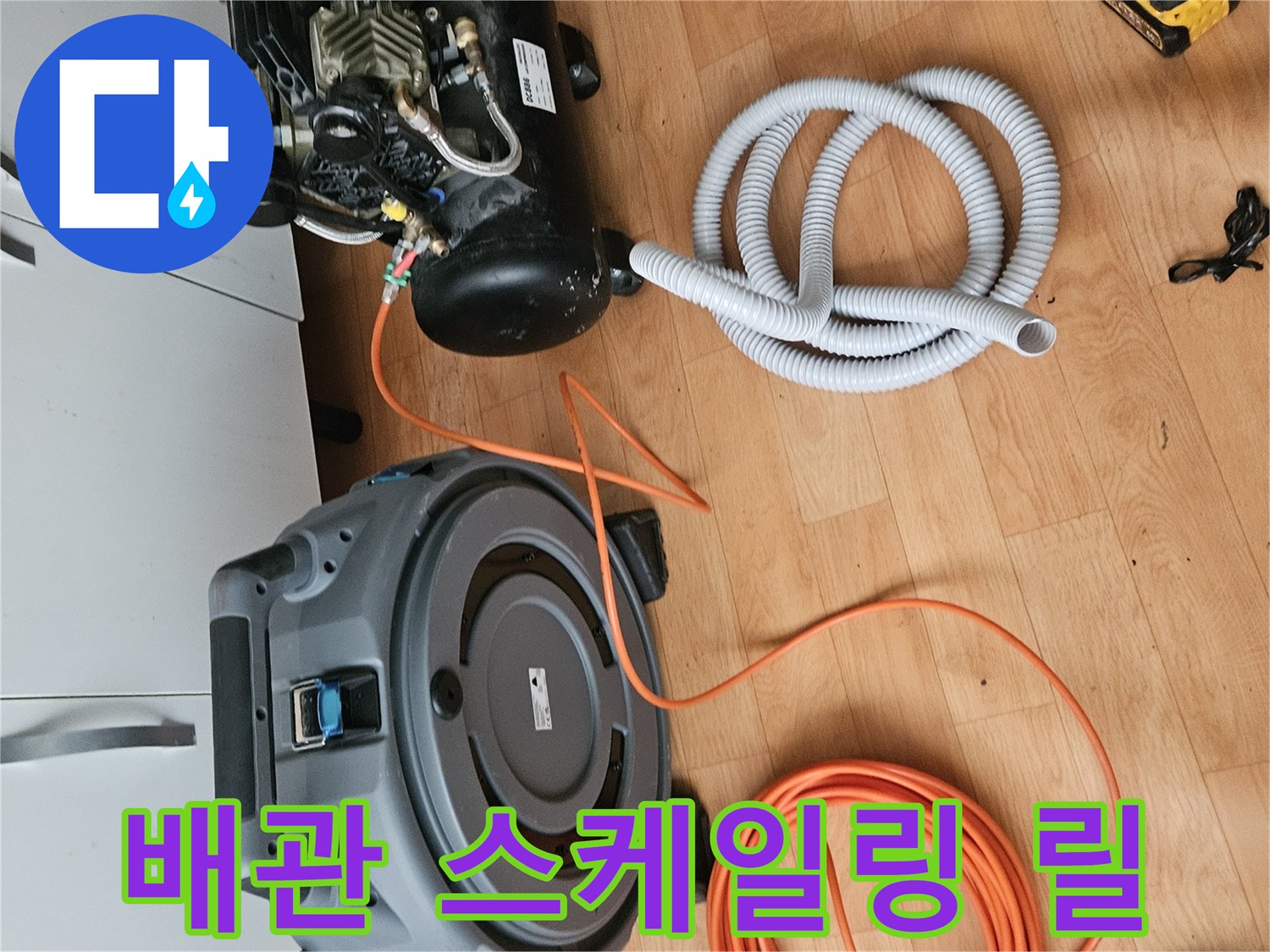 전동 장비와 연결된 긴 회색 배관 세척용 호스