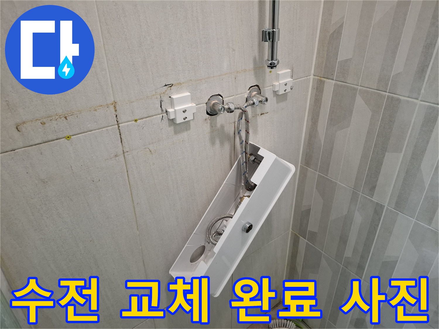 새로 설치된 샤워기 수전과 정돈된 욕실 벽면 타일