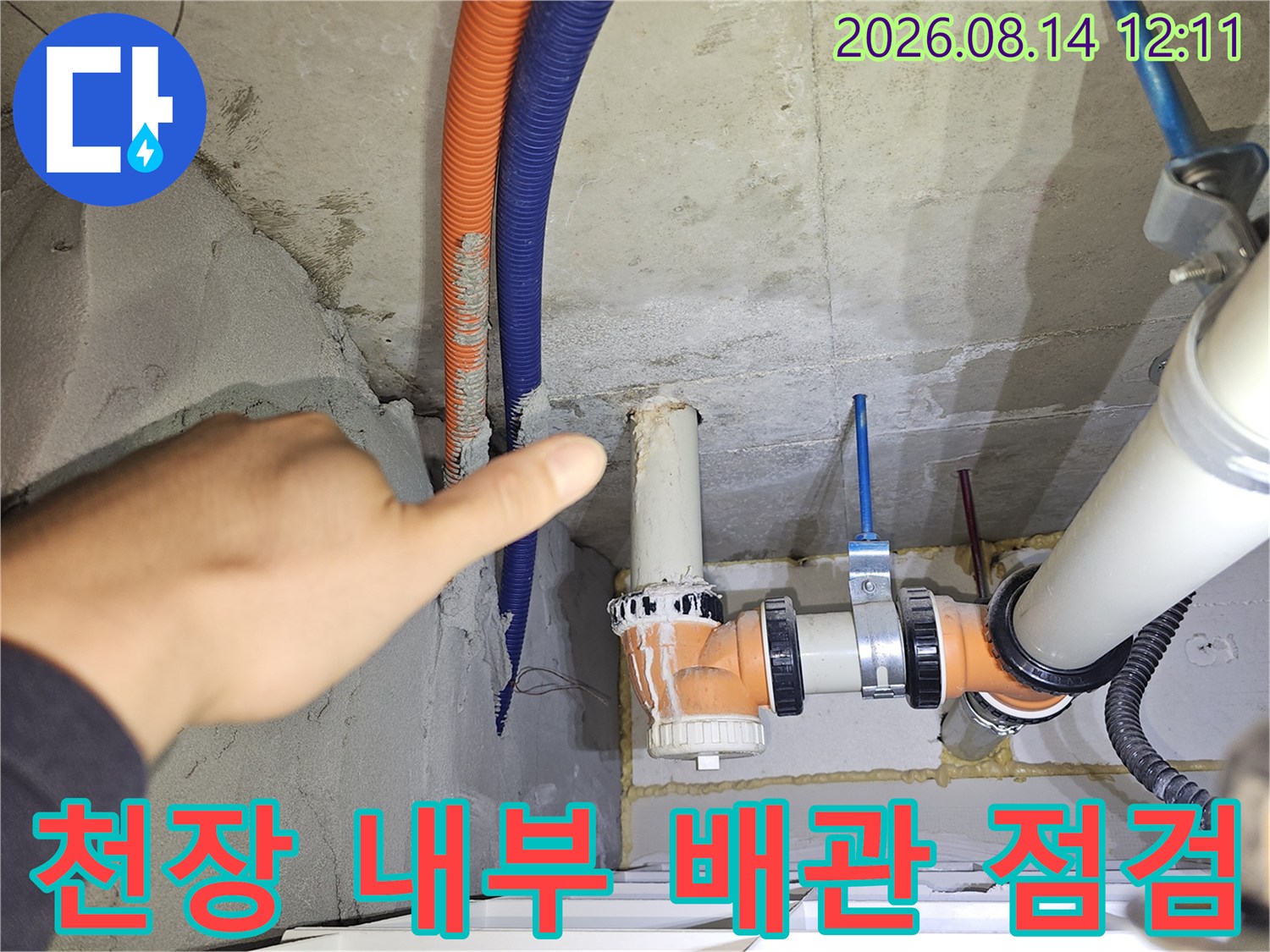 오렌지색 주름관과 파란색 호스가 연결된 천장 배관 구조