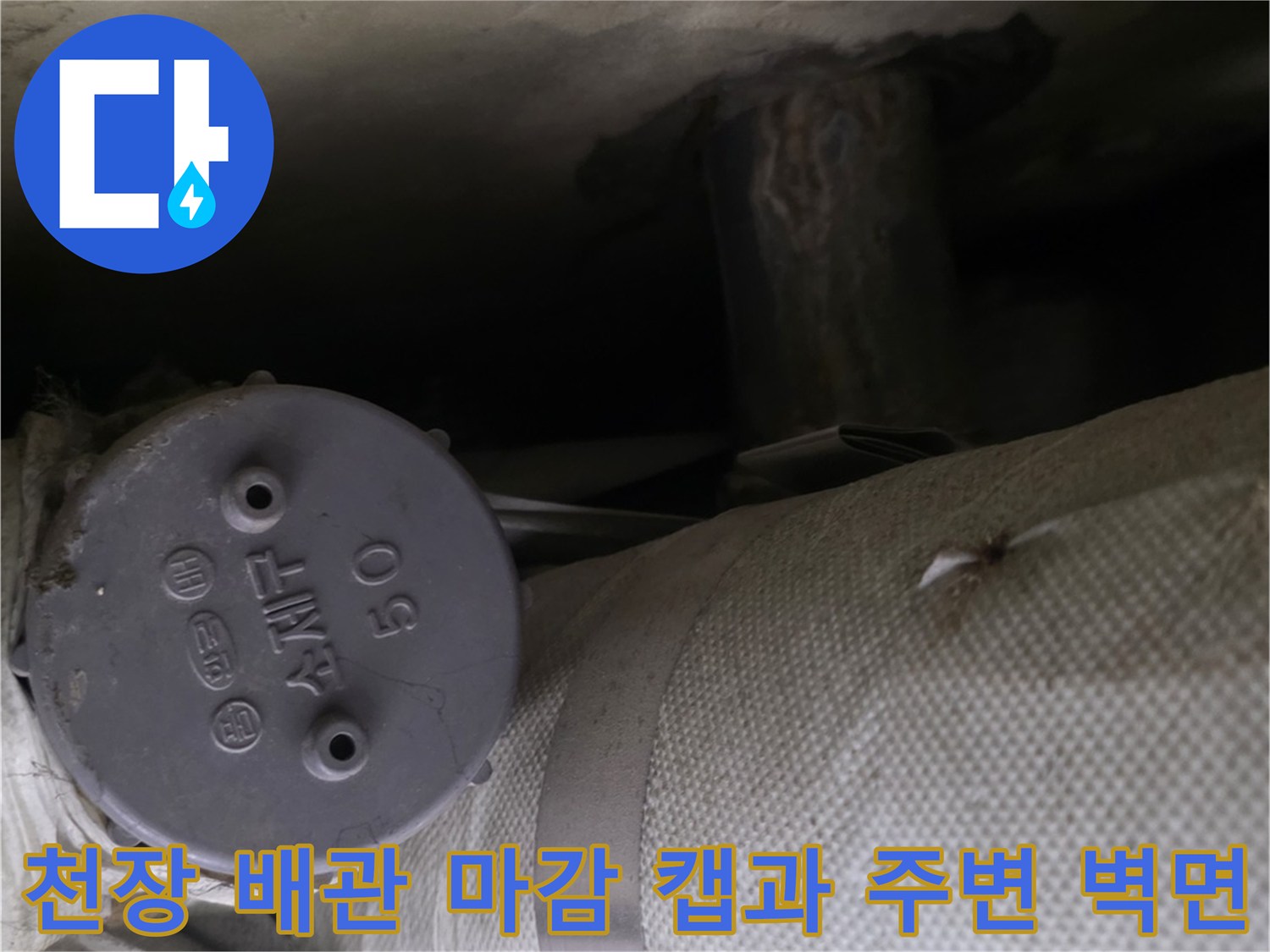 벽면에-밀착된-회색-배관-보온재와-원형-마감-캡의-근접-촬영샷