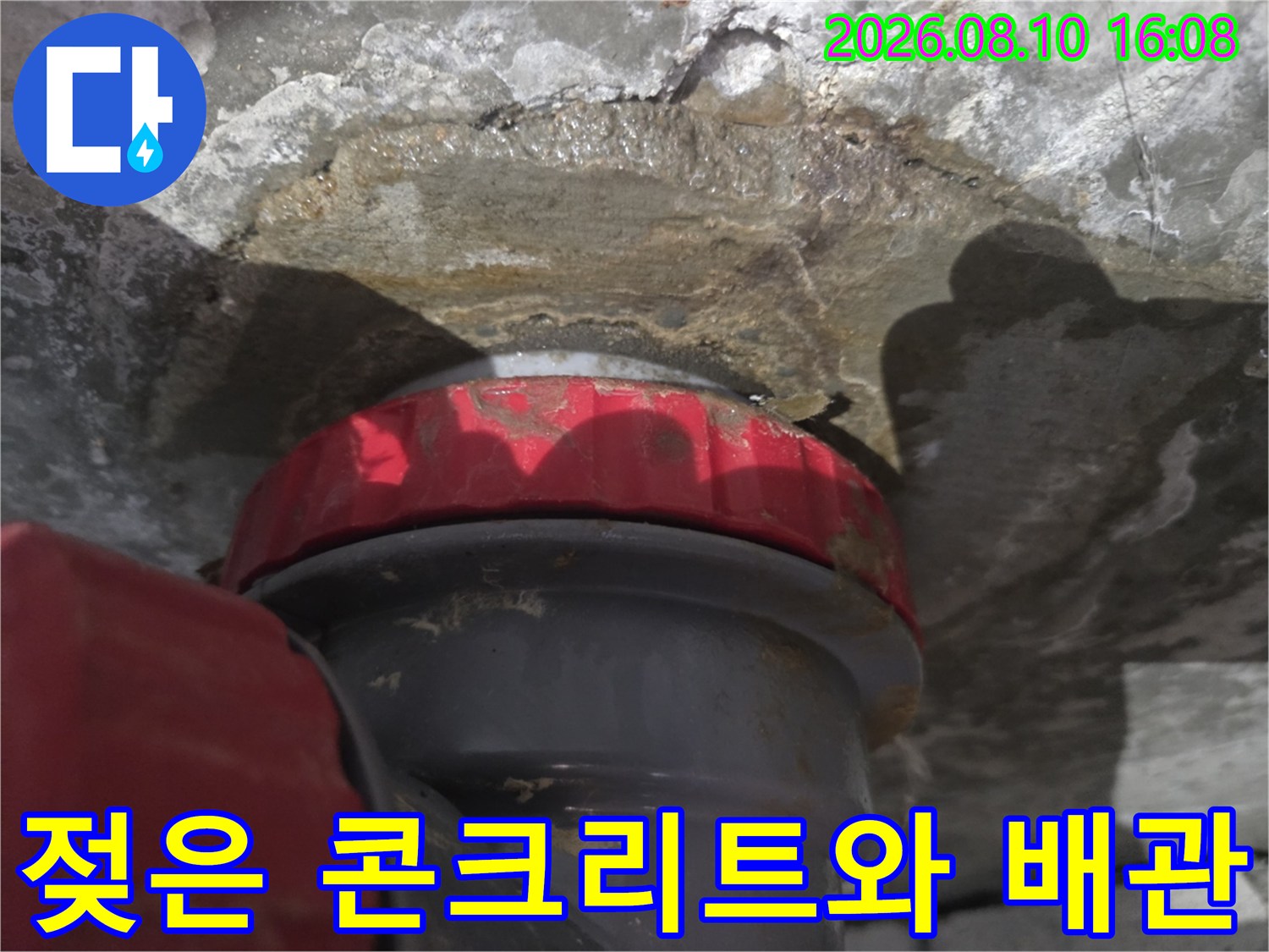 물에 젖어 어둡게 변색된 천장 배관 주변부