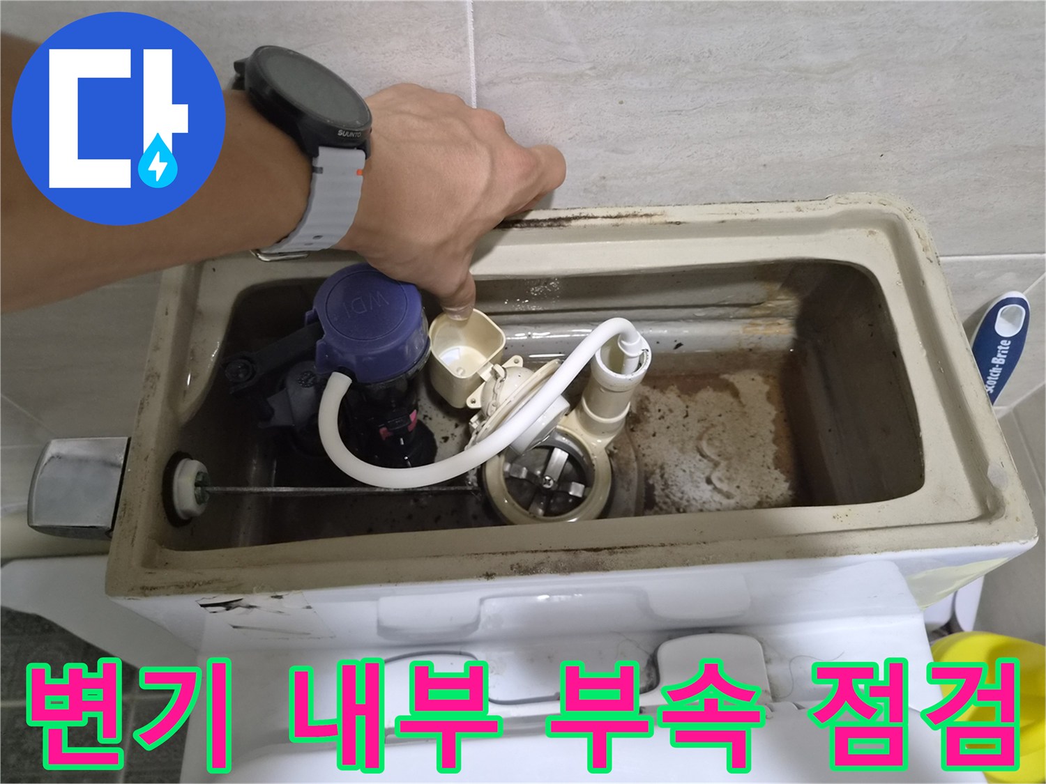 변기 수조 내부의 부속품과 필밸브를 손으로 확인하는 모습
