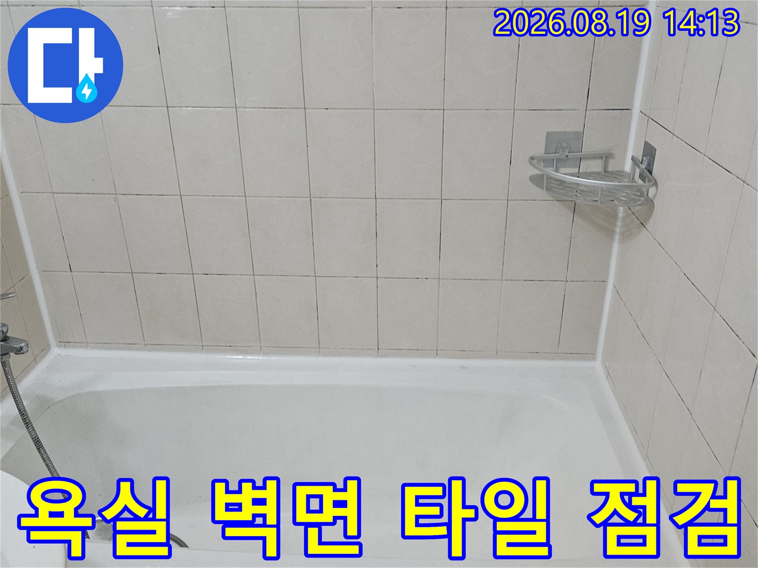 하얀색 타일 벽면과 욕조 경계 부위를 촬영한 사진입니다.