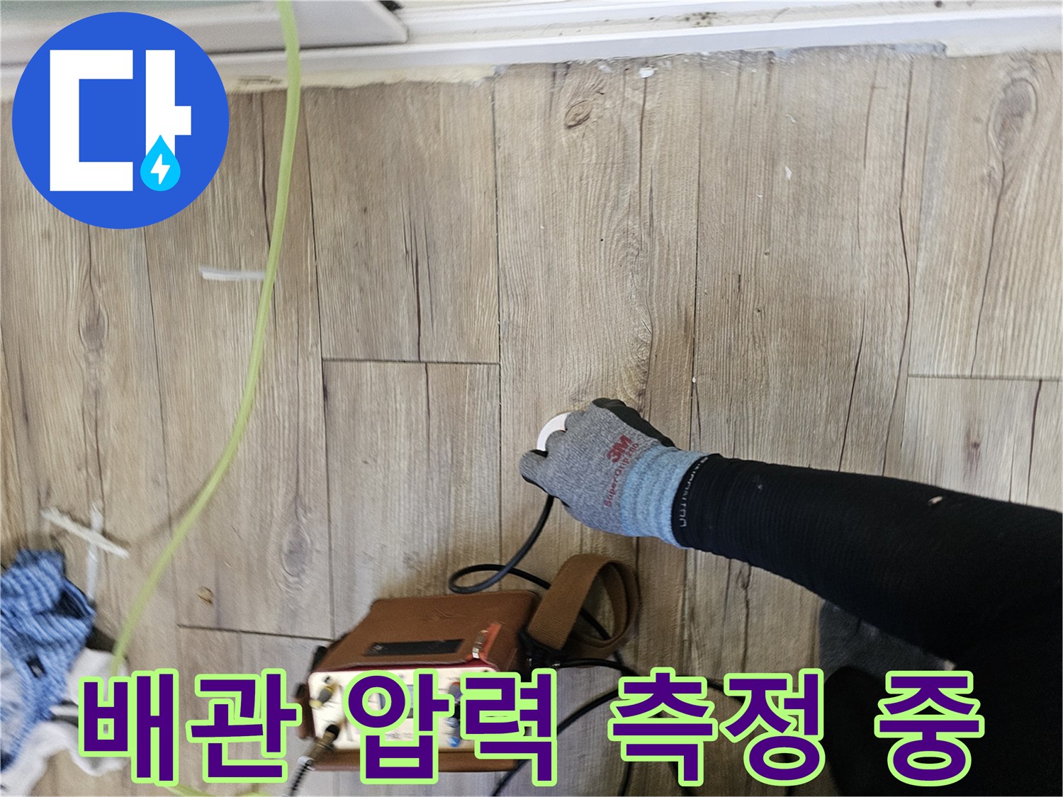 나무 마루 위에서 작동 중인 휴대용 배관 검사 장비