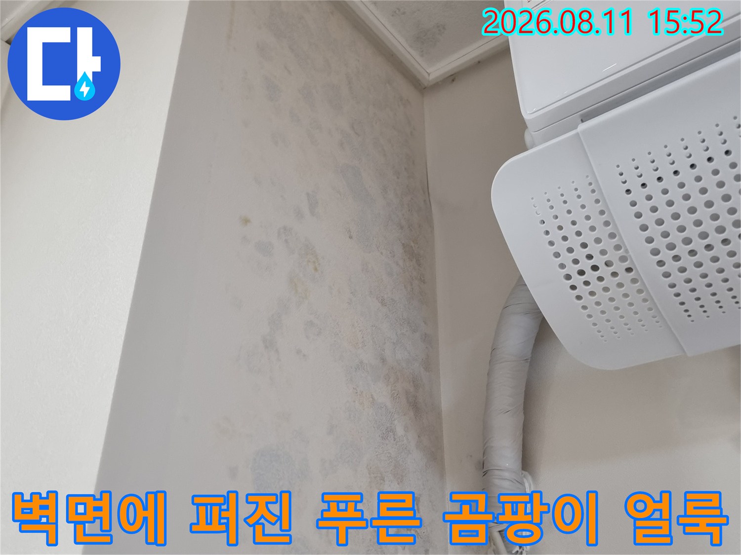 에어컨 실내기와 보온재로 감싸진 배관 아래쪽 벽면에 나타난 광범위한 누수 얼룩