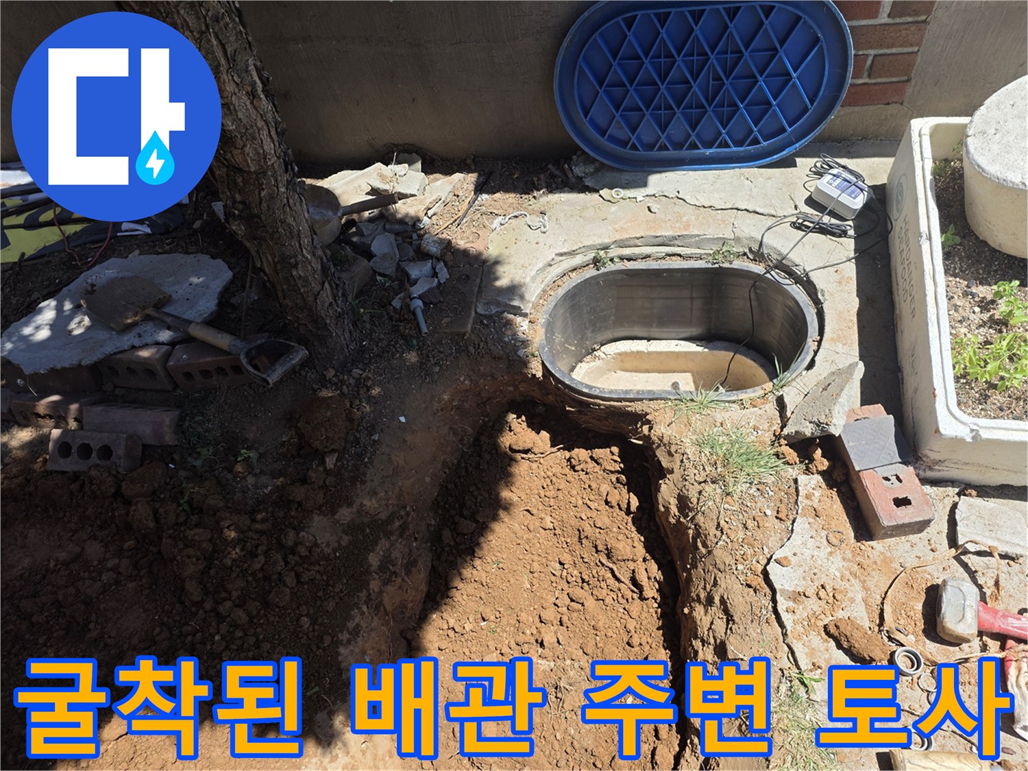 맨홀 근처-배관 확인을 위해 파헤쳐진 흙과 도구들