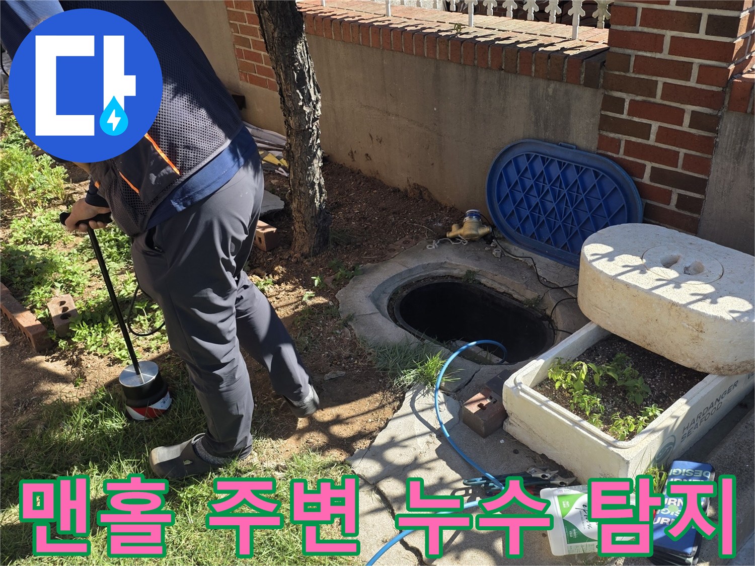 맨홀과 나무 사이의-지면을 정밀하게 탐색하는 공사 현장 사진입니다.