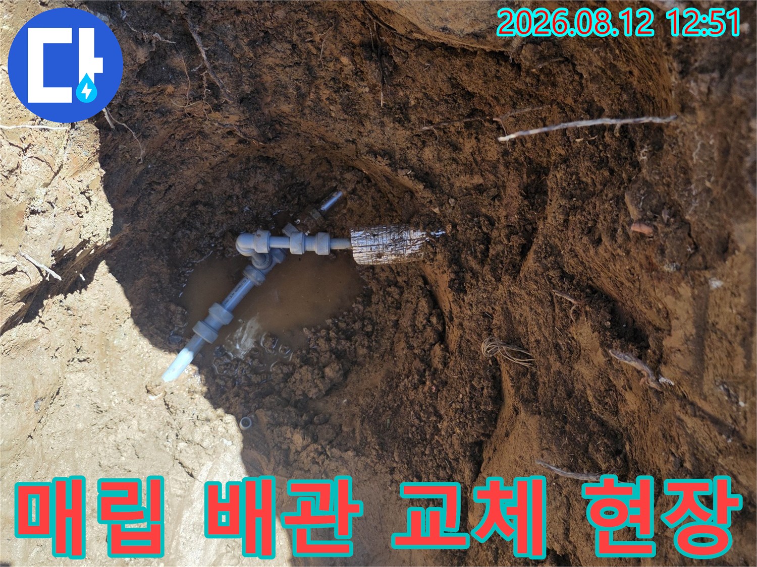 지면 아래 굴착된 공간에 노출된 파손 배관과 연결 부품의 모습입니다.