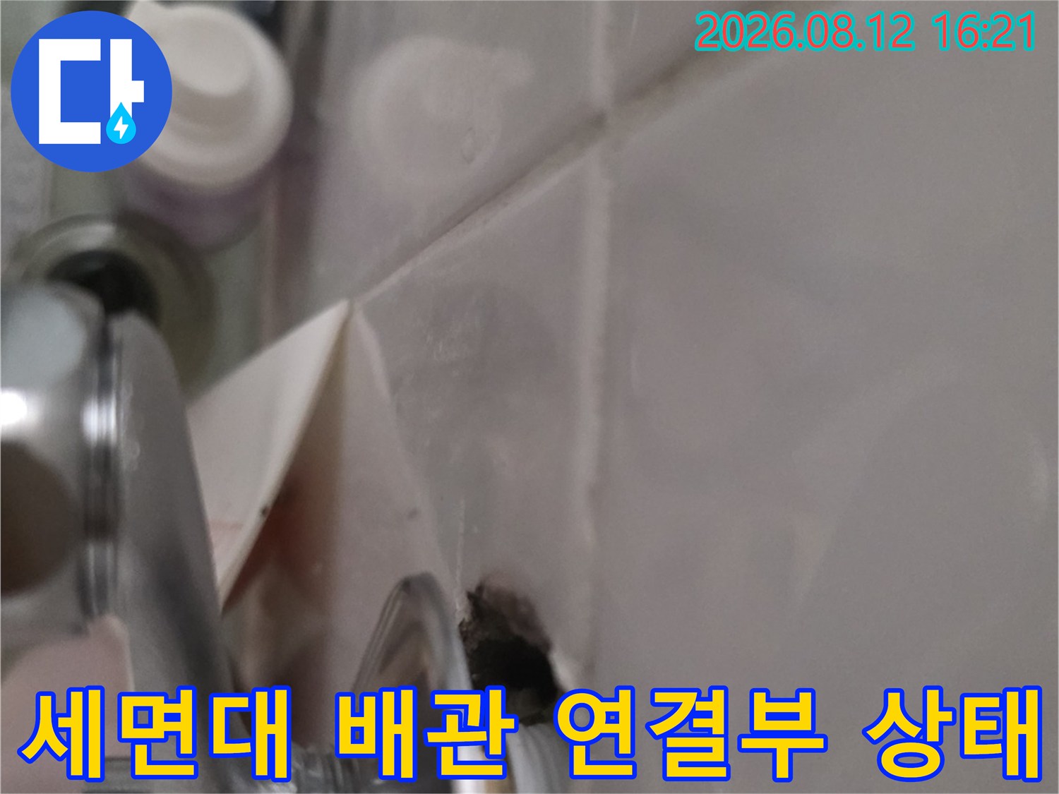 욕실 세면대 아래쪽의 금속제 배수 배관과 타일 접합 부위-누수 점검 사진