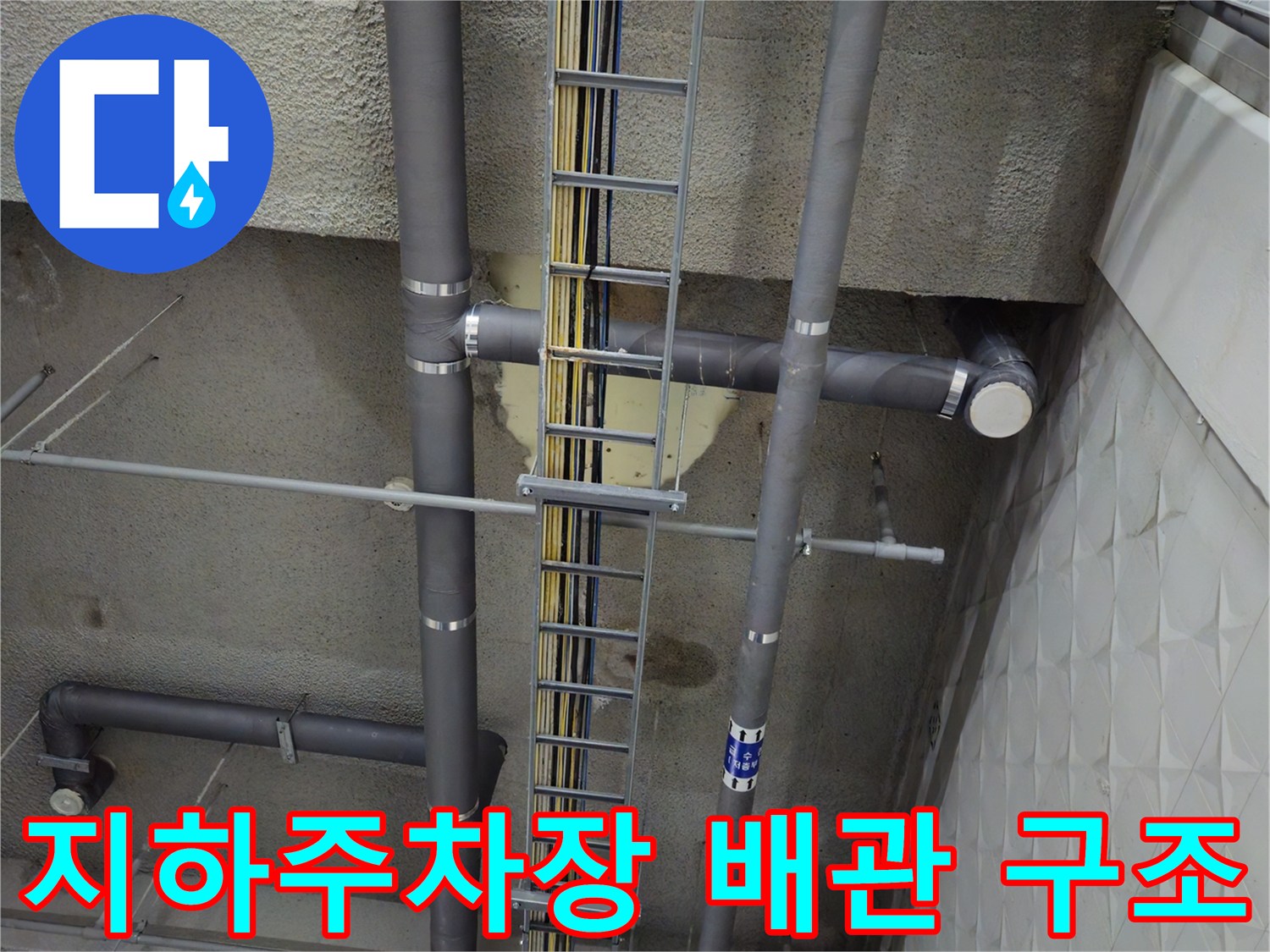 지하 주차장의 천장 배관 및 케이블 트레이 설비 사진입니다.