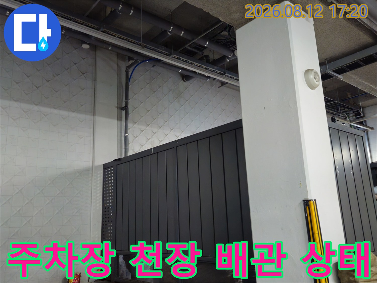 지하주차장 천장에 설치된 금속 구조물과 배관 시설의 근접 촬영본입니다.