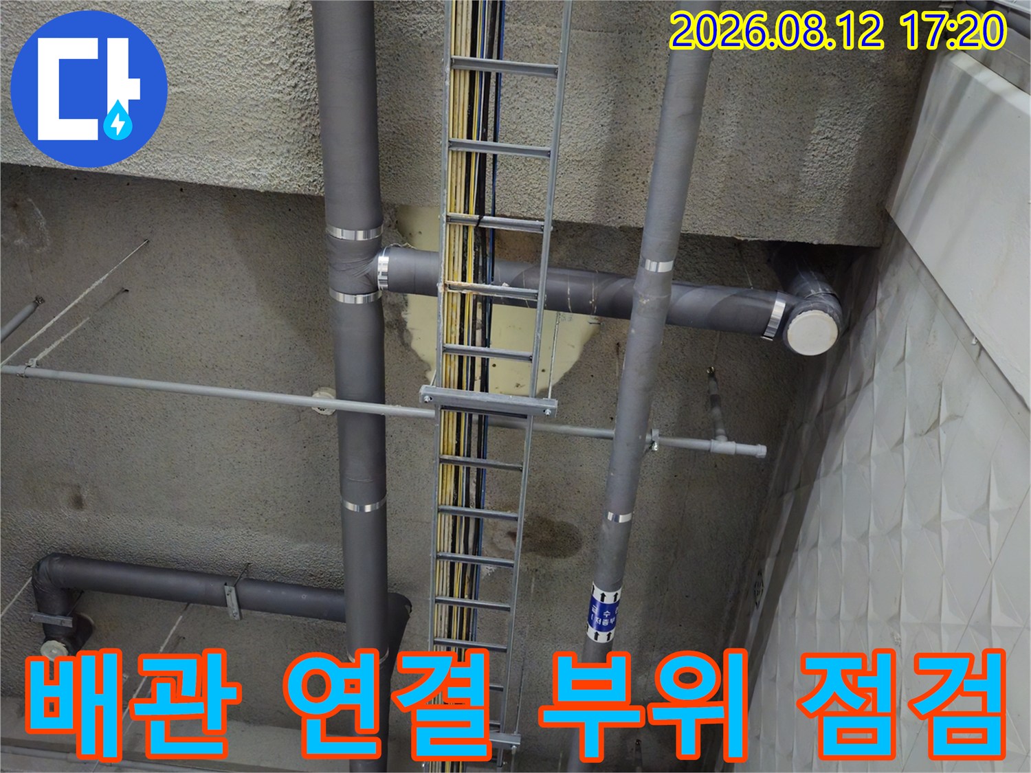 회색 PVC 배관과 전기 트레이가 설치된 지하 주차장 천장 모습