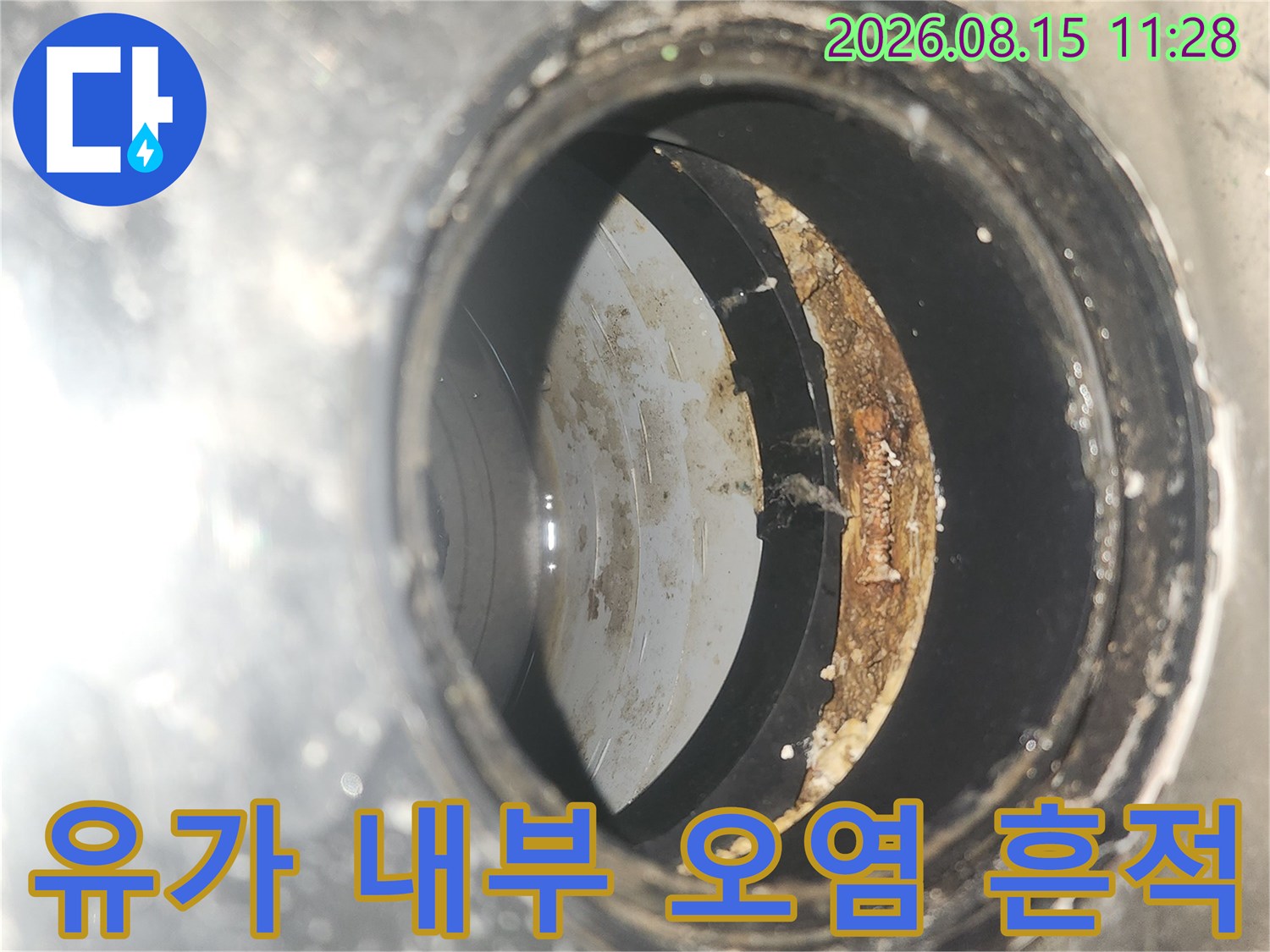유가 안쪽의 배관 연결 부위와 오염된 이물질을 근접 촬영한 사진입니다.