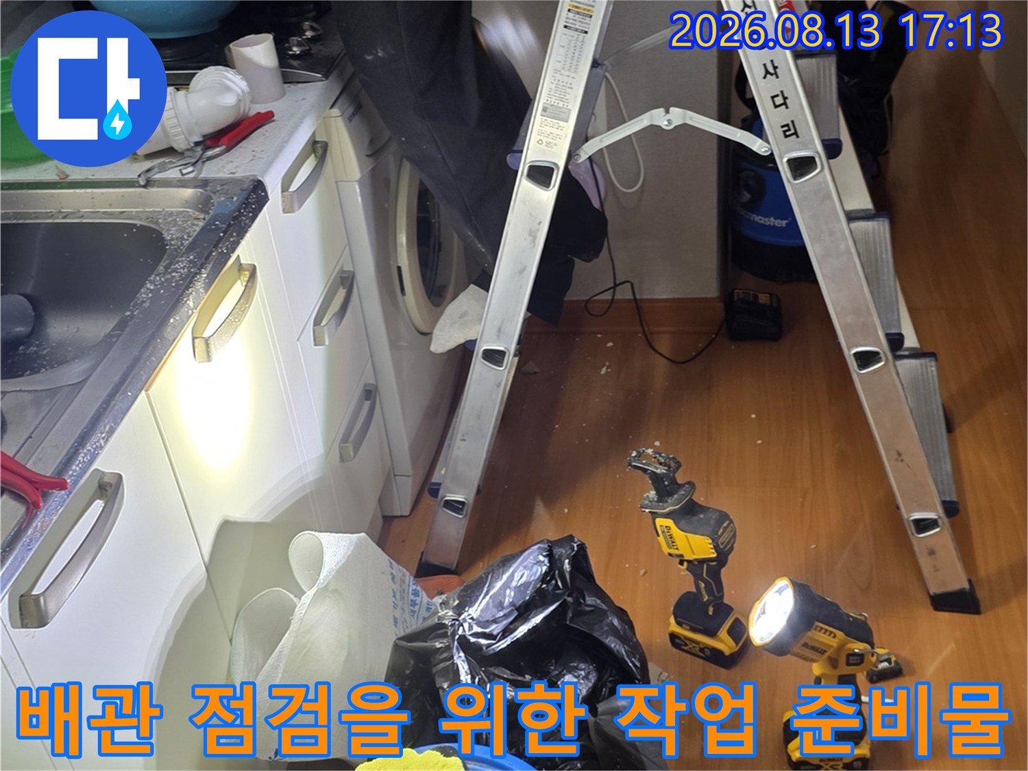 상부장 뒤쪽 배관 확인을 위해 사다리와 전동 드릴을 배치한 현장 모습