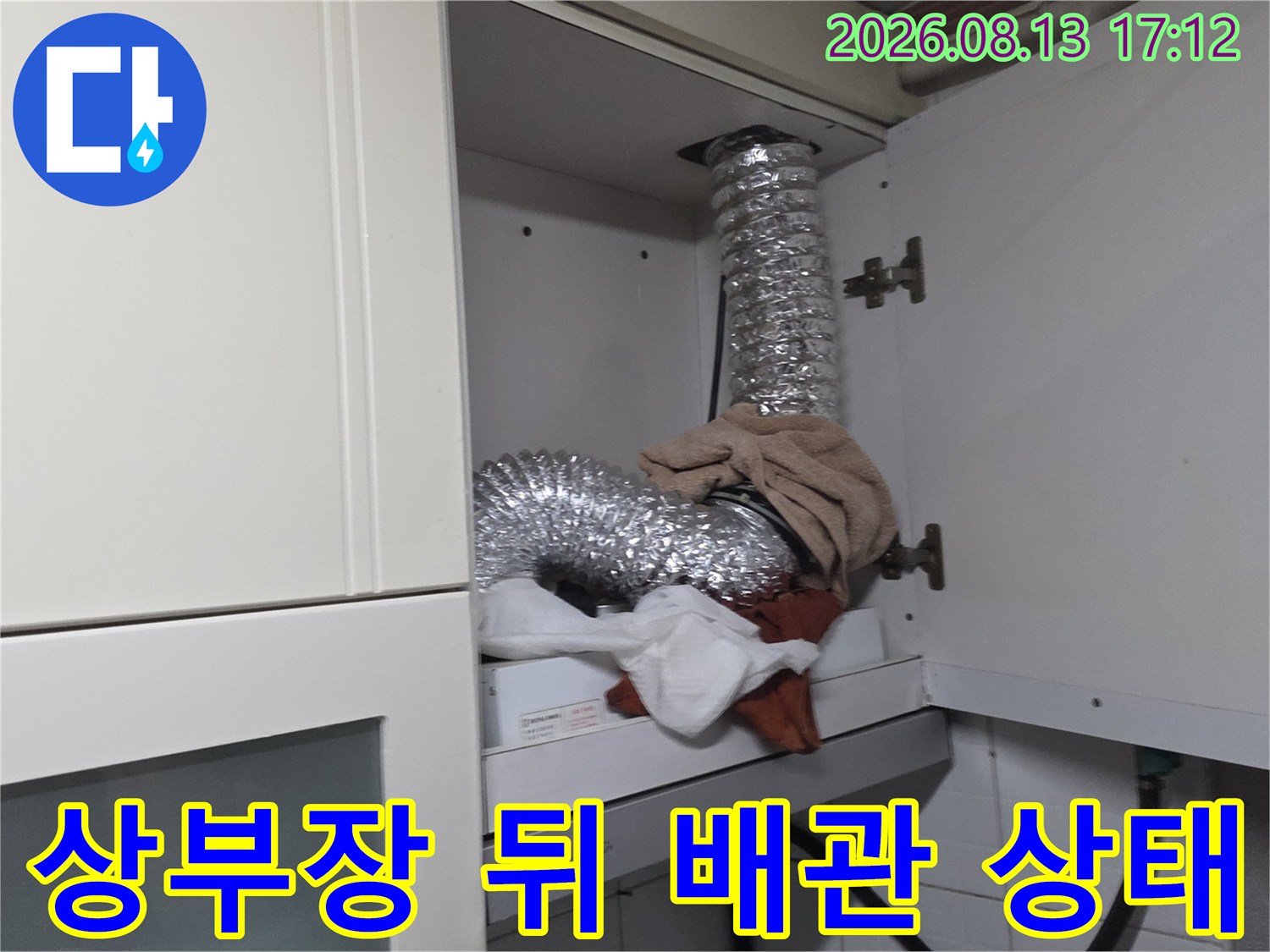 싱크대 상부장 안쪽 은색 배관과 연결 부위의 노출된 모습