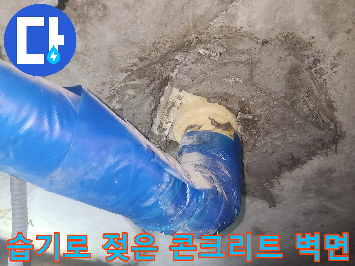 콘크리트 벽면의 젖은 얼룩과 배관 연결부 노출