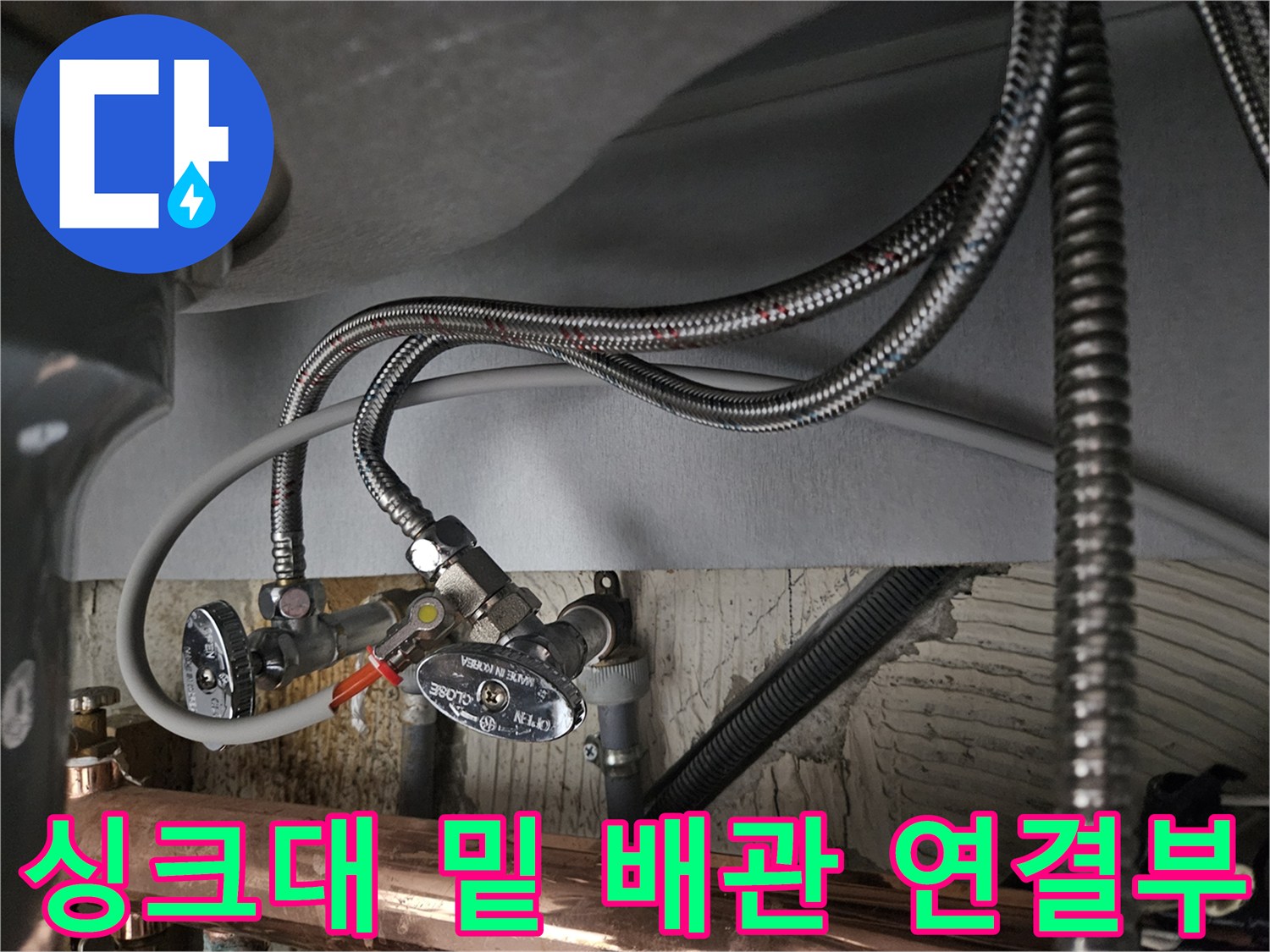 싱크대 하단부에 설치된 은색 꼬임 호스와 급수 조절 밸브