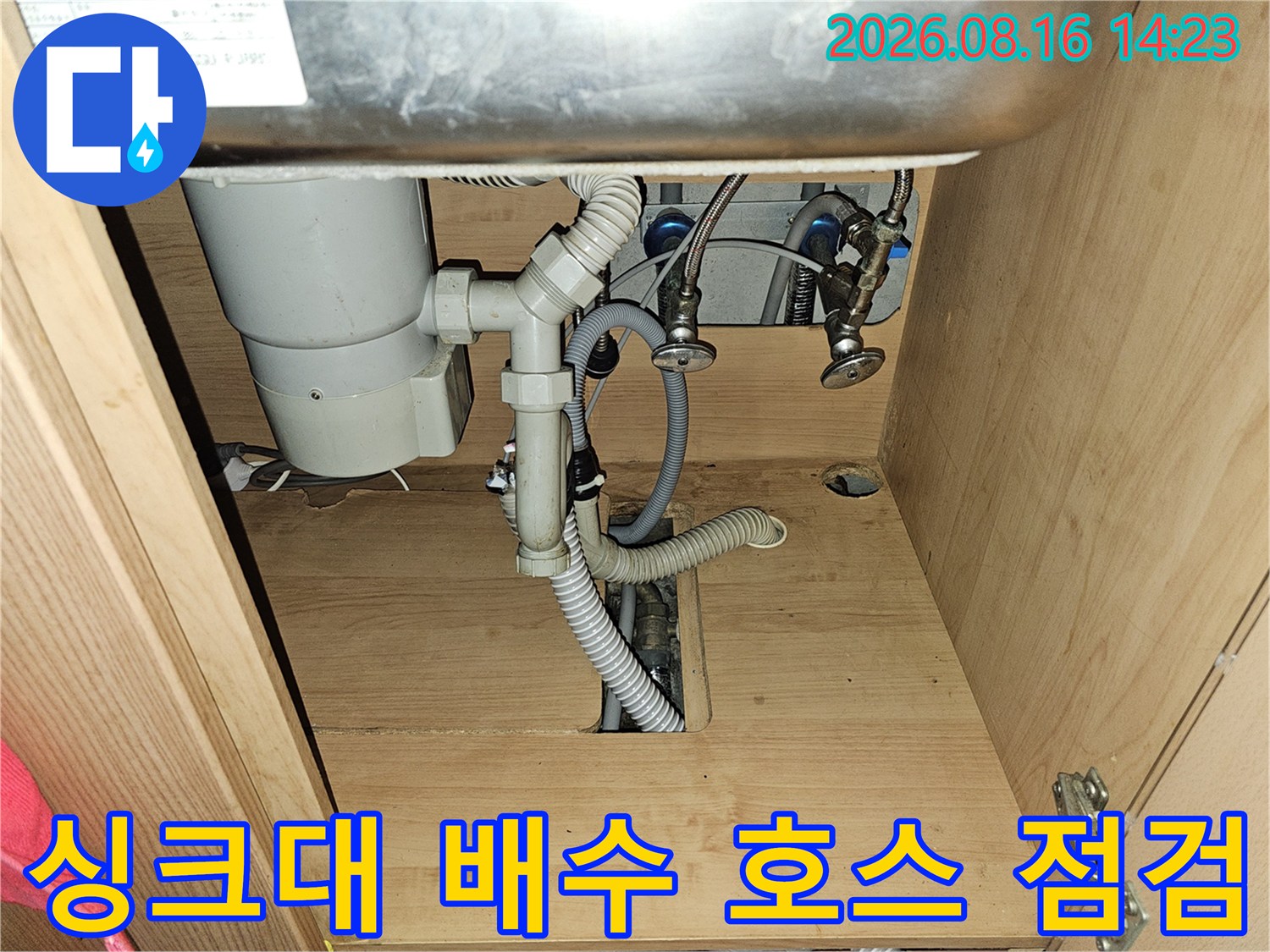 싱크대 아래쪽의 굴곡진 하수 배관과 밸브 모습
