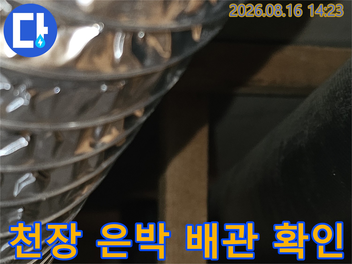 은색 주름관과 검은색 배관이 천장 내부에 설치된 모습입니다.