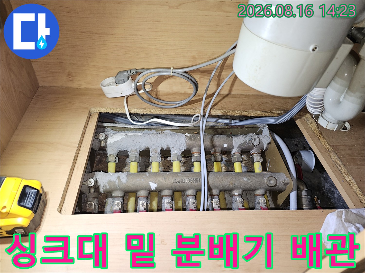 하부장 내부에 위치한 금속 재질의 보일러 분배기와 연결된 배관들입니다.