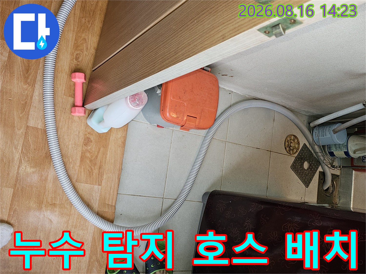 화장실 입구 바닥을 가로질러 연결된 누수 점검용 장비 호스