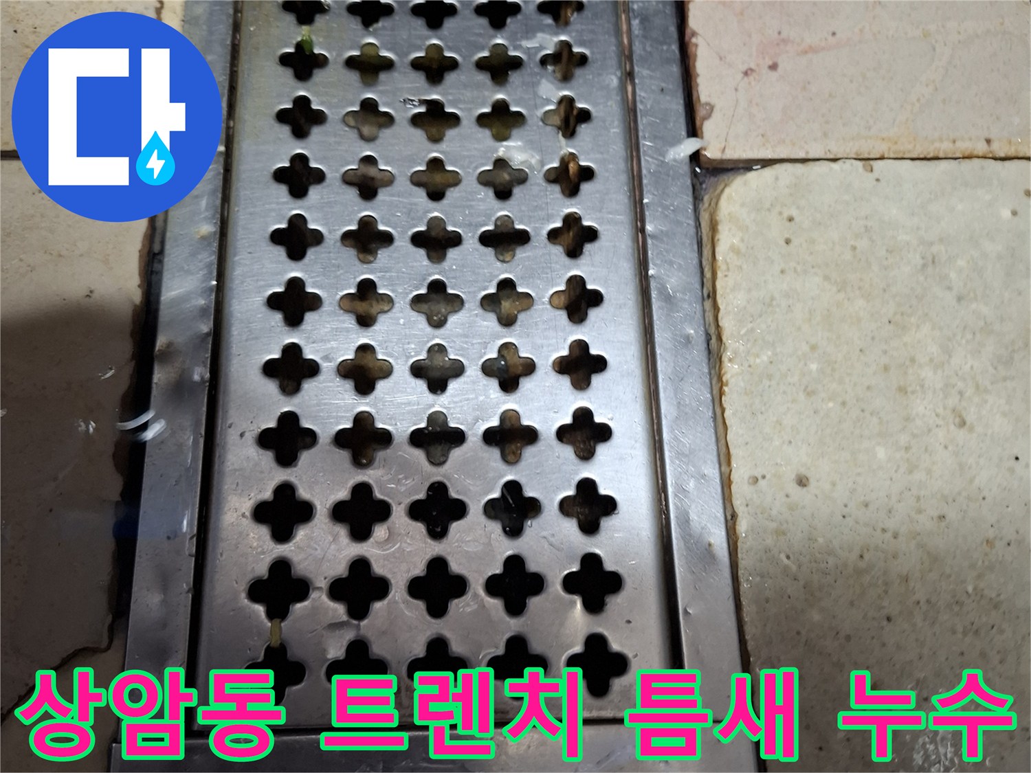 배수 트렌치 금속판 주변의 벌어진 타일 틈새와 물 흔적
