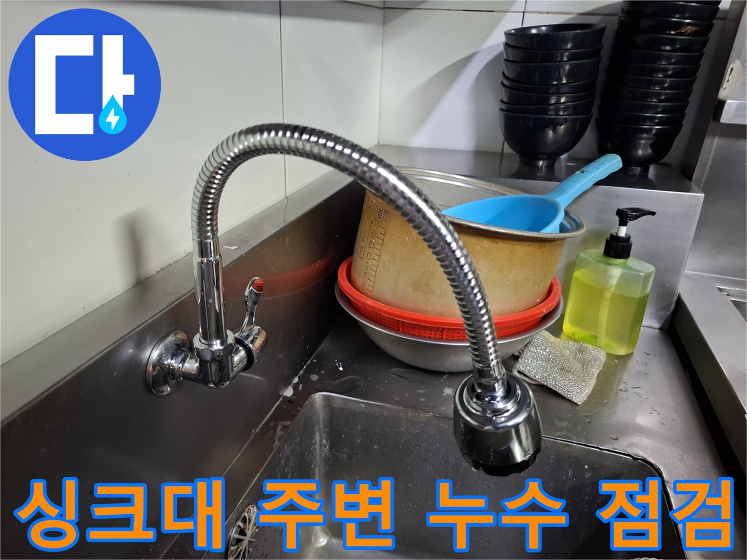 상암동 식당 주방의 싱크대 수전과 배수 시설 근처 현장 사진입니다.
