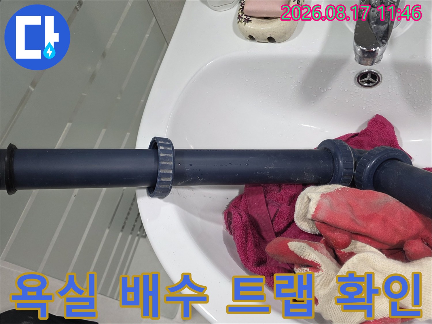 세면대 아래쪽 짙은 색 배관과 연결 부위의 상태를 근접 촬영한 사진