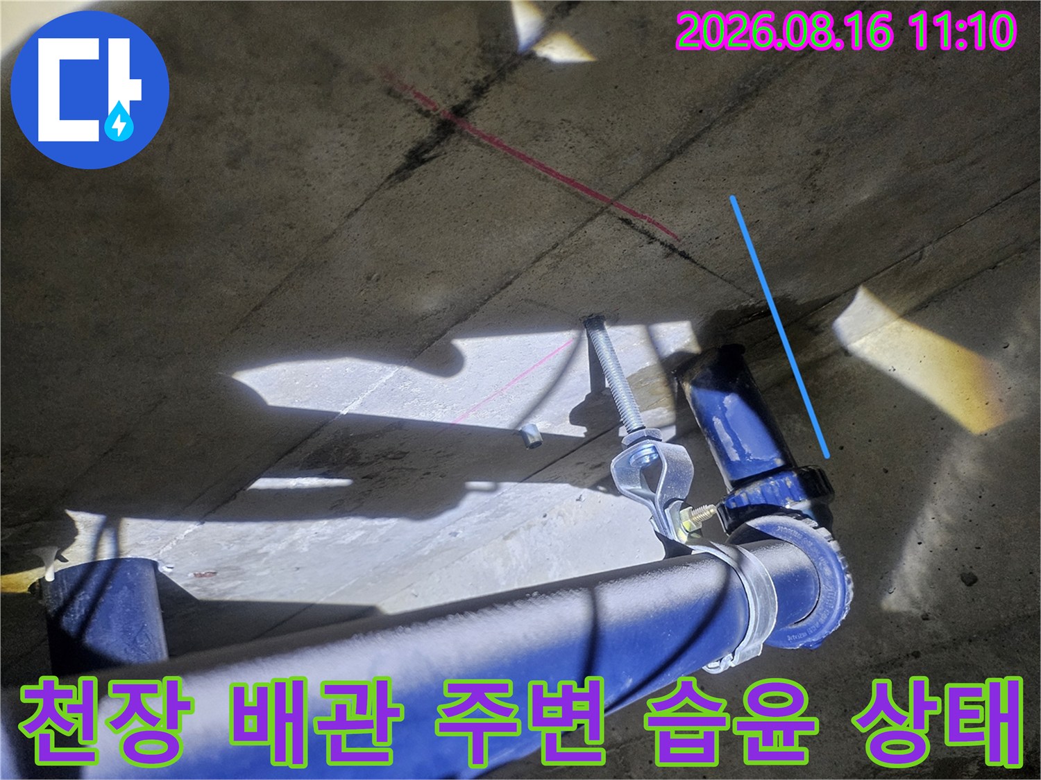 파란색 배관 주위의 젖은 콘크리트 슬라브 표면