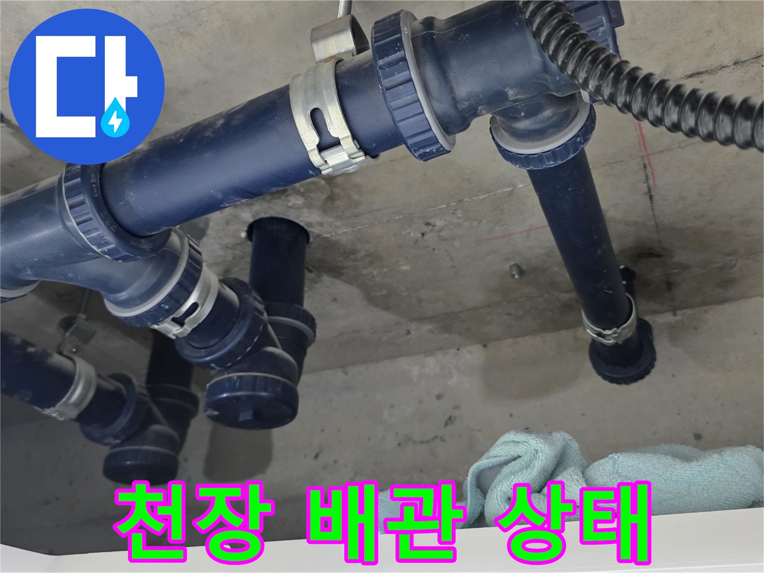 화장실 천장 내부의 파란색 배관과 젖은 콘크리트 면