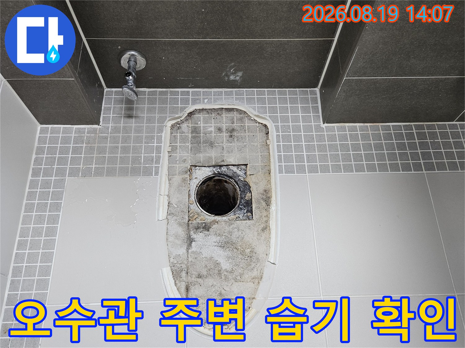변기 제거 후 노출된-오수관 부근의 젖은 타일과 오염 상태
