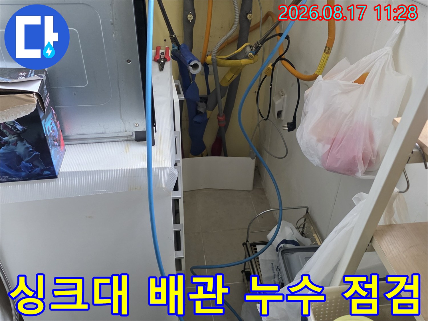 싱크대 하단 싱크대 하부장 내부의 수도 배관과 정수기 호스 상태를 보여줍니다.